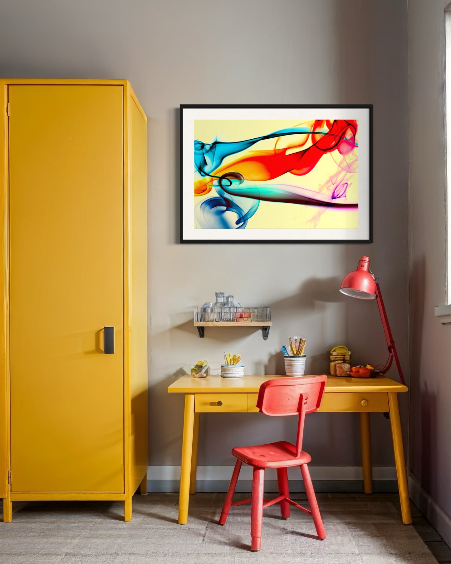 Yellow cabinet, red chair, and desk with colorful abstract art on a gray wall.