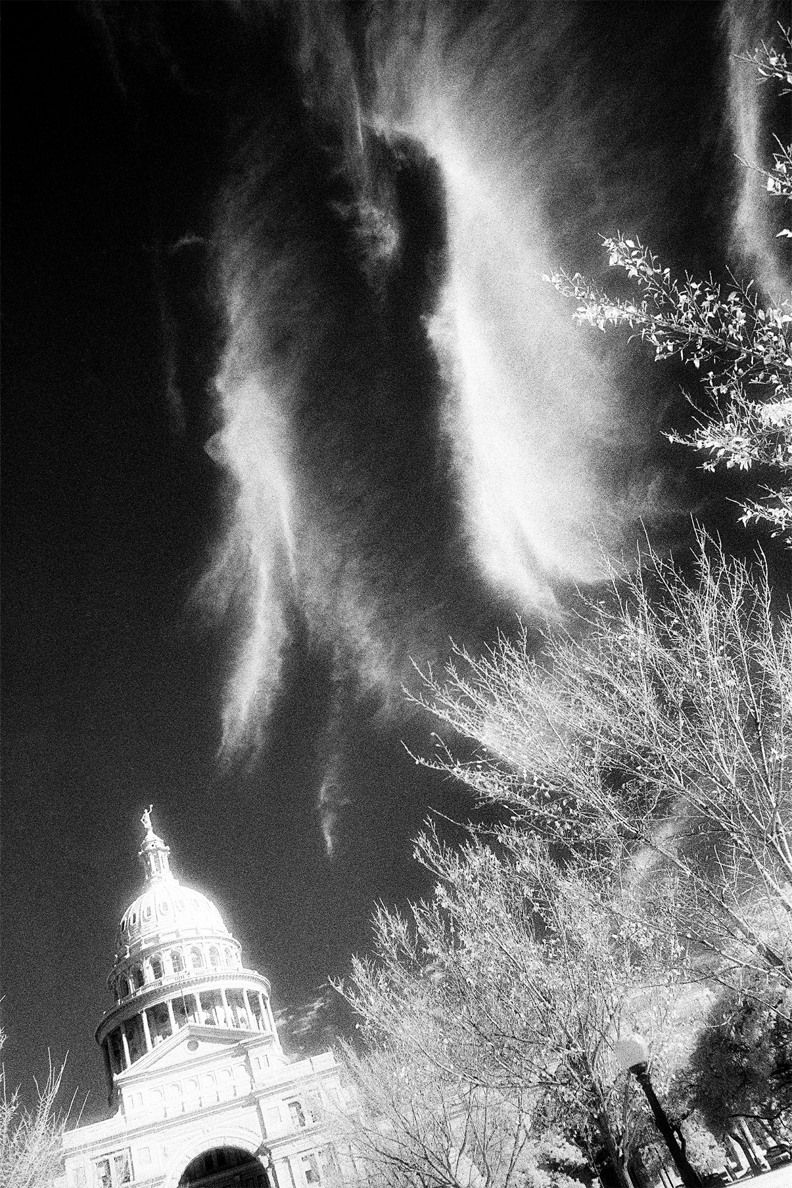 black and white photo, top of capitol building, dramatic clouds