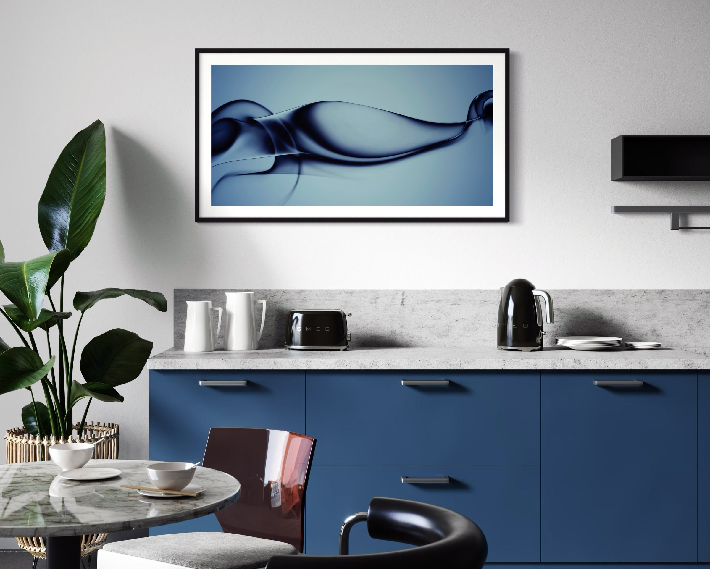 Modern kitchen with blue cabinets, a sleek marble countertop, and black appliances. A large plant stands by a round table with bowls, beneath abstract art.