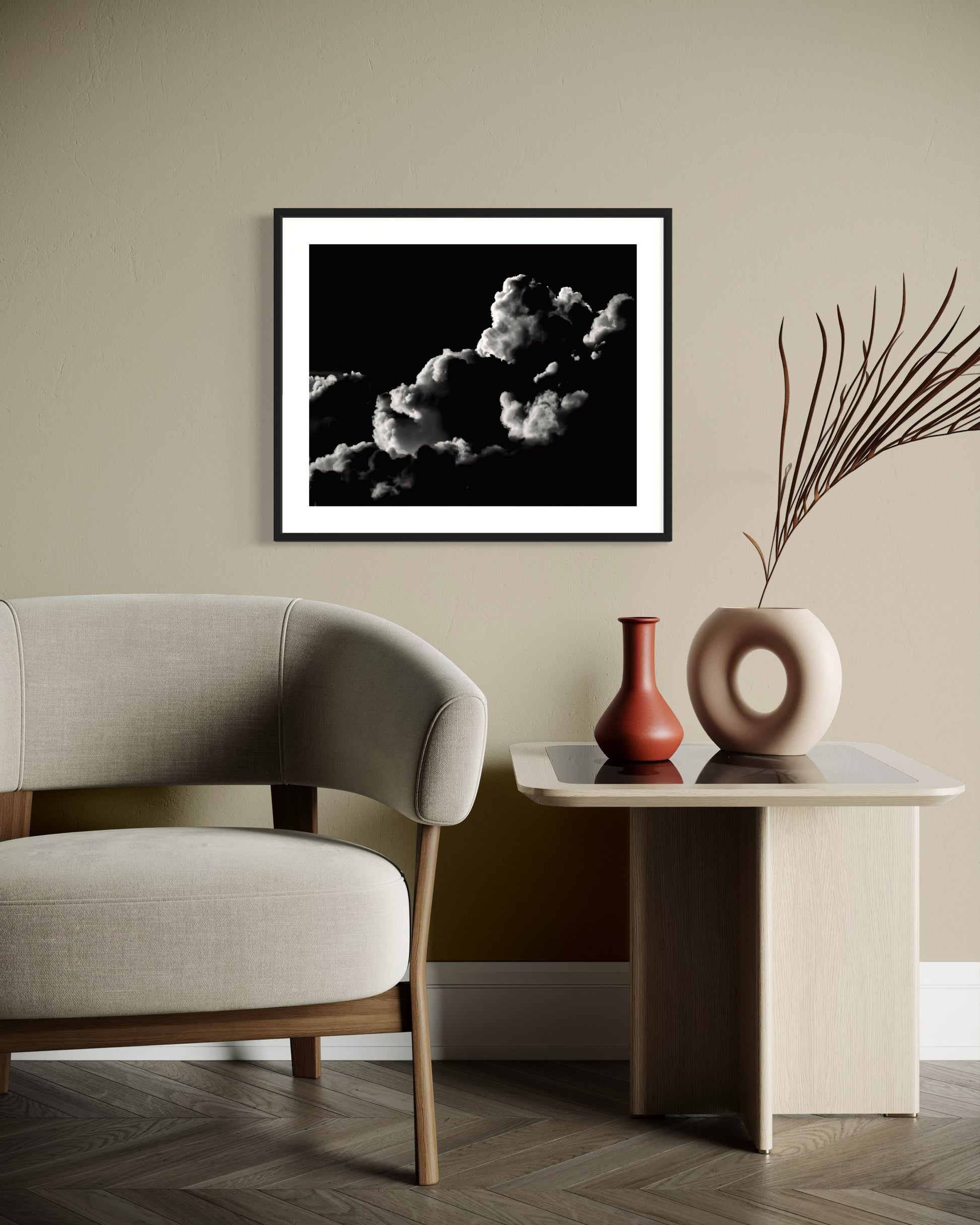 black and white photo of clouds, one looks like a dog's head in profile in black frame with white matte on tan wall in modern earth toned sitting area