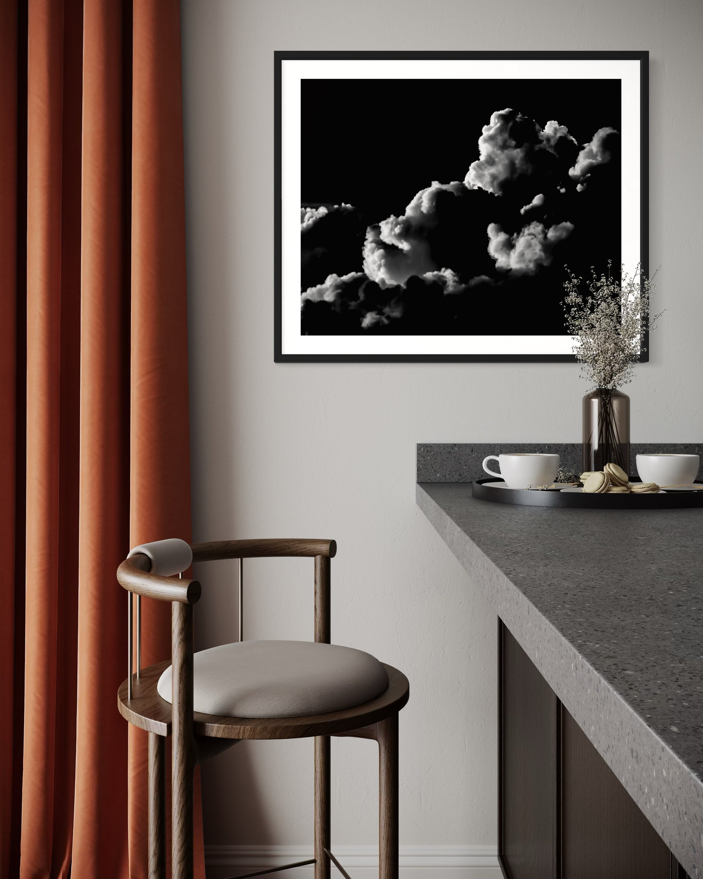 black and white photo of clouds, one looks like a dog's head in profile in black frame with white matte on off white wall in modern kitchen corner