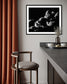 black and white photo of clouds, one looks like a dog's head in profile in black frame with white matte on off white wall in modern kitchen corner