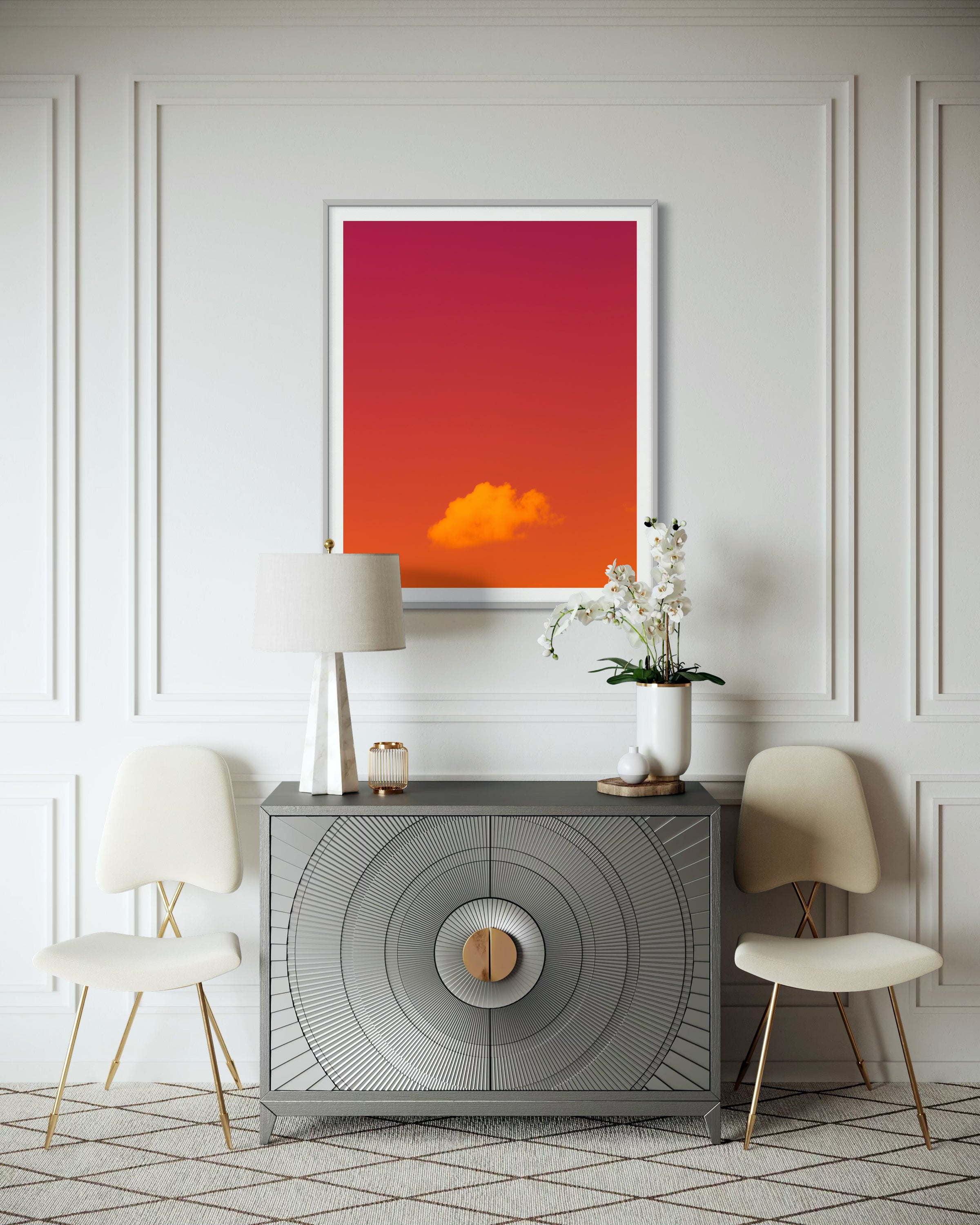 warm tone photo of single cloud in gray frame with white matte on white wall in upscale residential sitting area with light warm tones