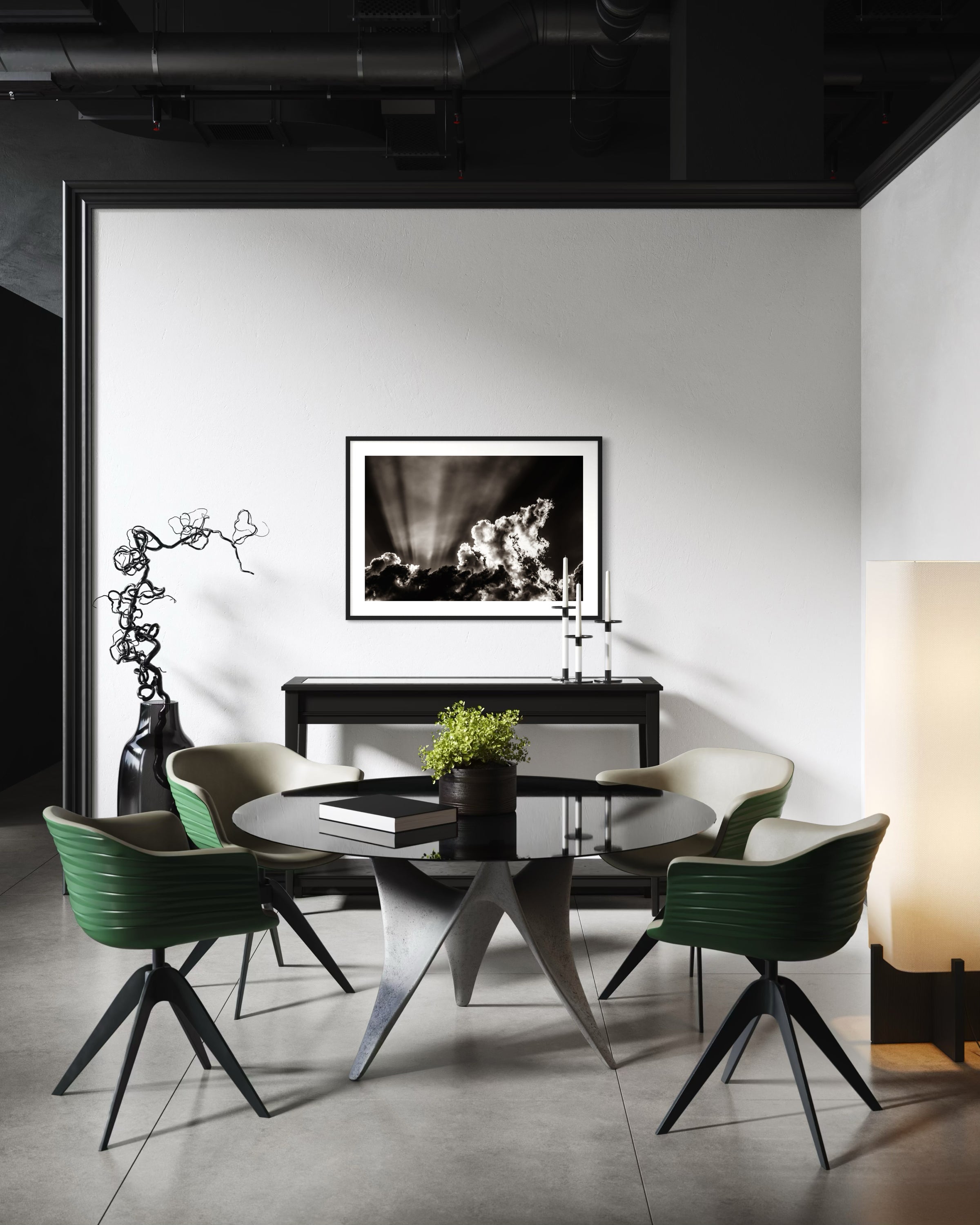 black and white photo of dramatic sky with some clouds and rays of light  in black frame with white matte on white wall in modern breakfast area with green chairs and concrete floors