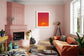 warm tone photo of single cloud in black frame with white matte on pink wall in colorful living room