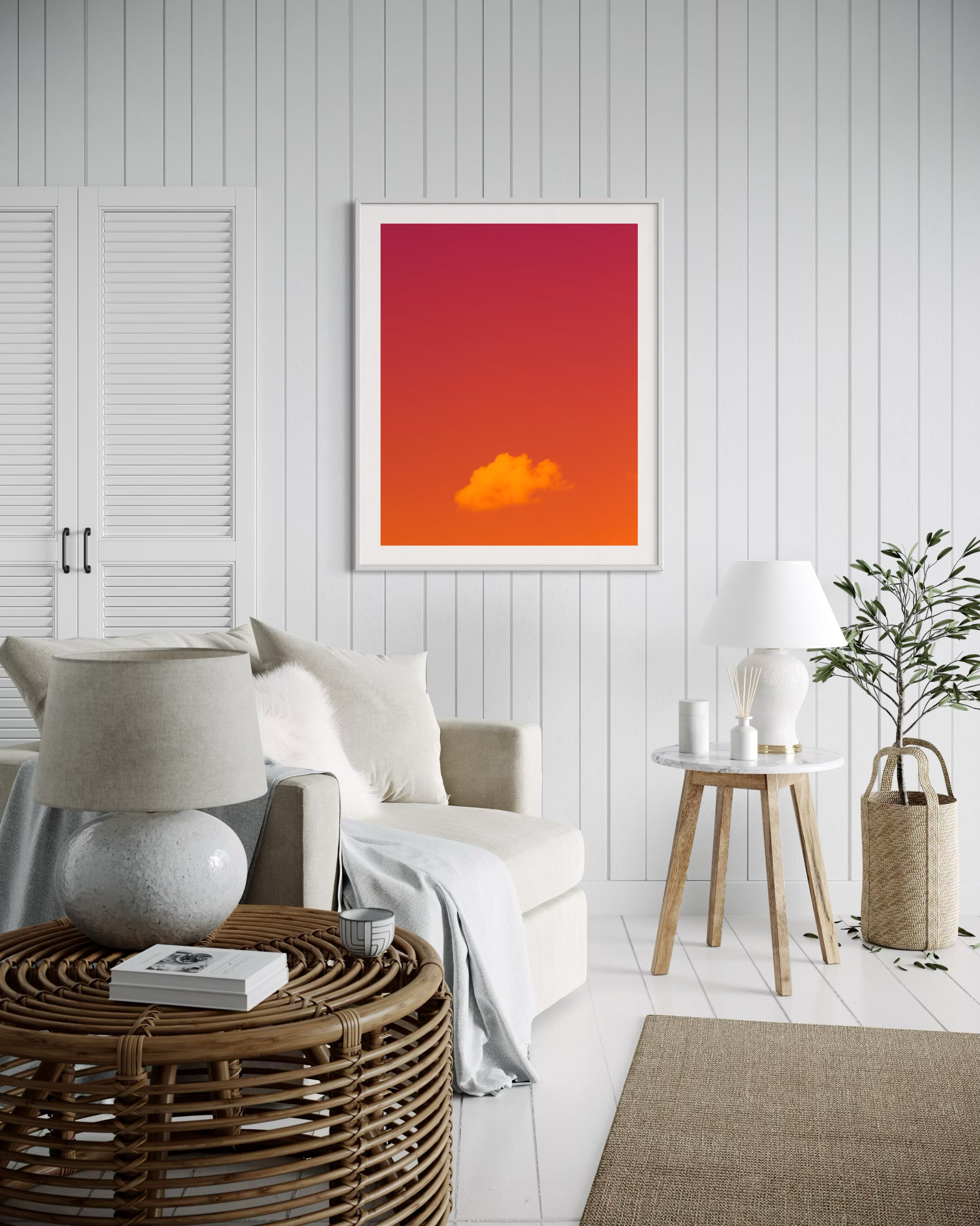 warm tone photo of single cloud in white frame with white matte on light white wall in beach house sitting area with white tones and light tan accents