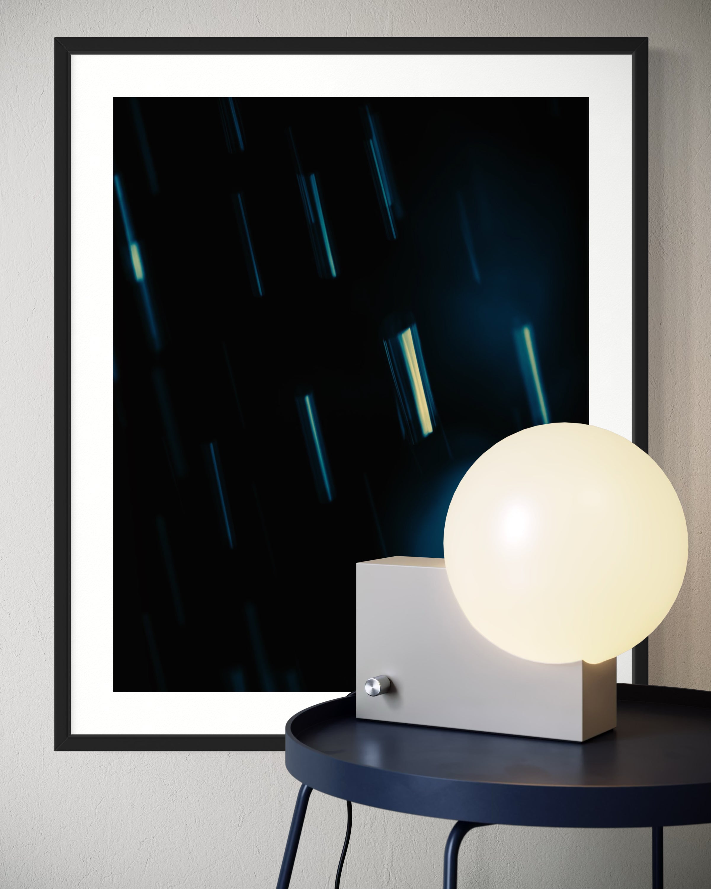 close up cool toned photo of streaks of rain in black frame with white matte on white wall above modern small table with illuminated white globe covering the lower right cover of the framed photo