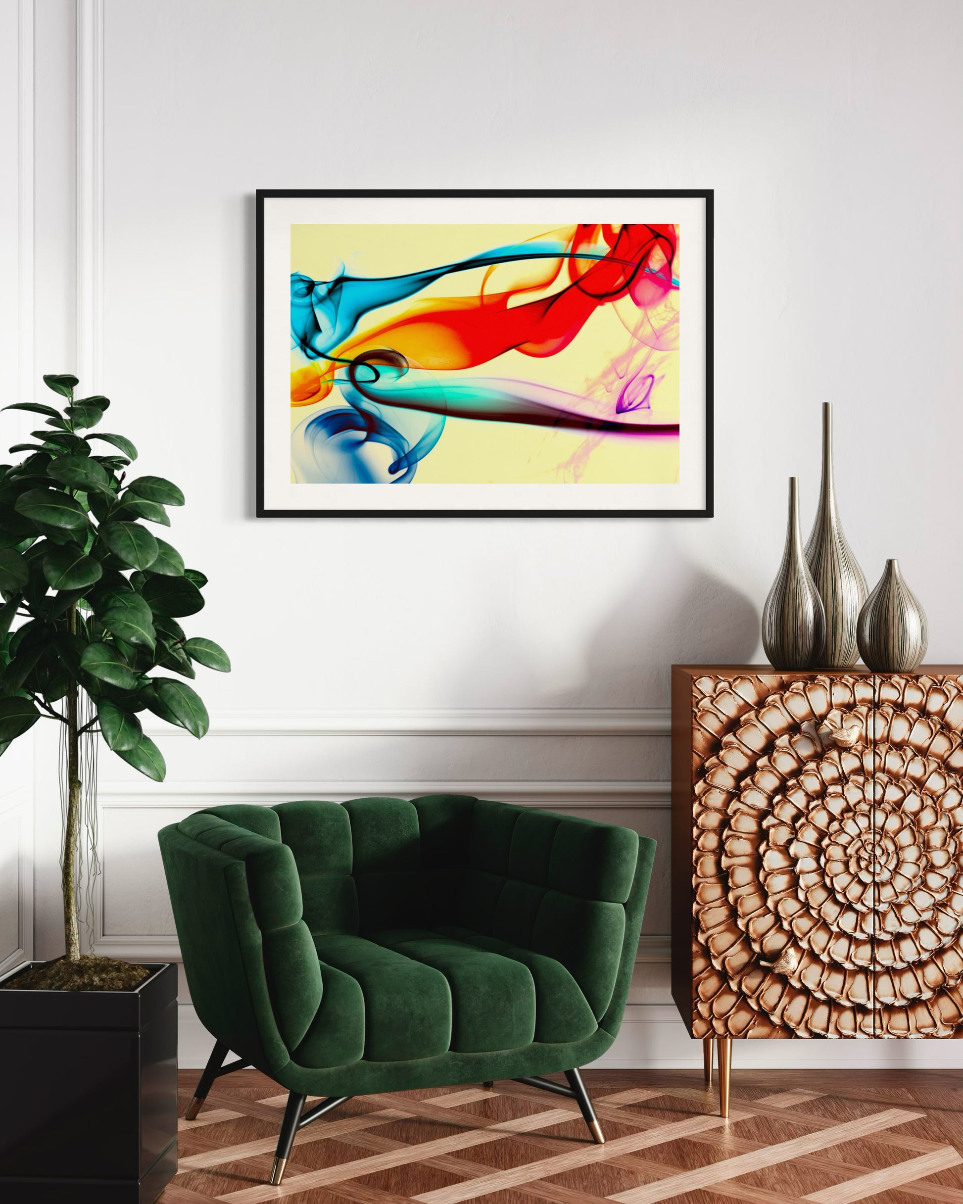 swirls of blue, yellow, orange, teal, purple and red on light yellow background in black frame with off white matte on light tan wall in modern sitting room with dark green chair and tall green plant