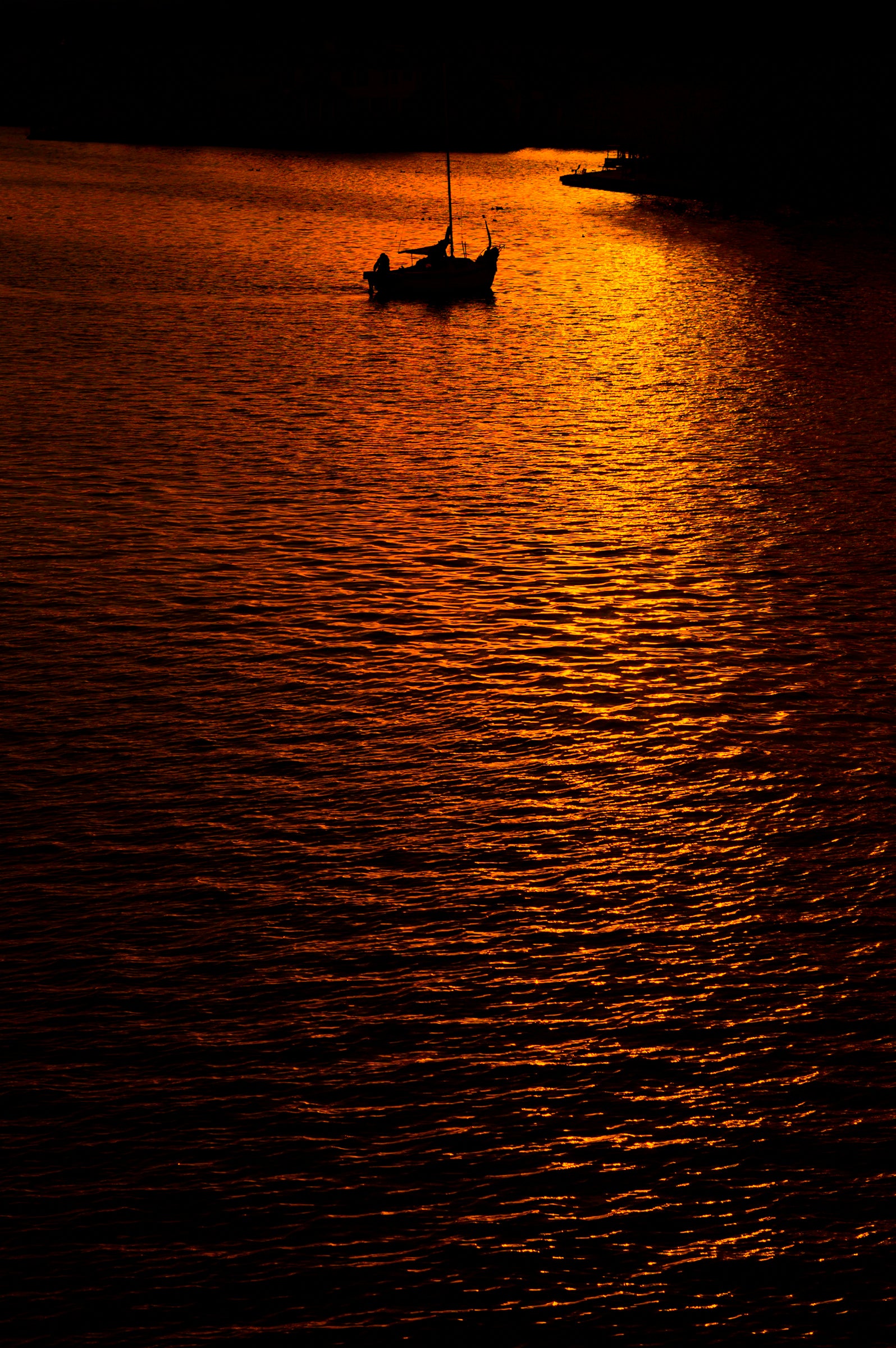 photo of sailboat sailing at sunset, in a very warm tone