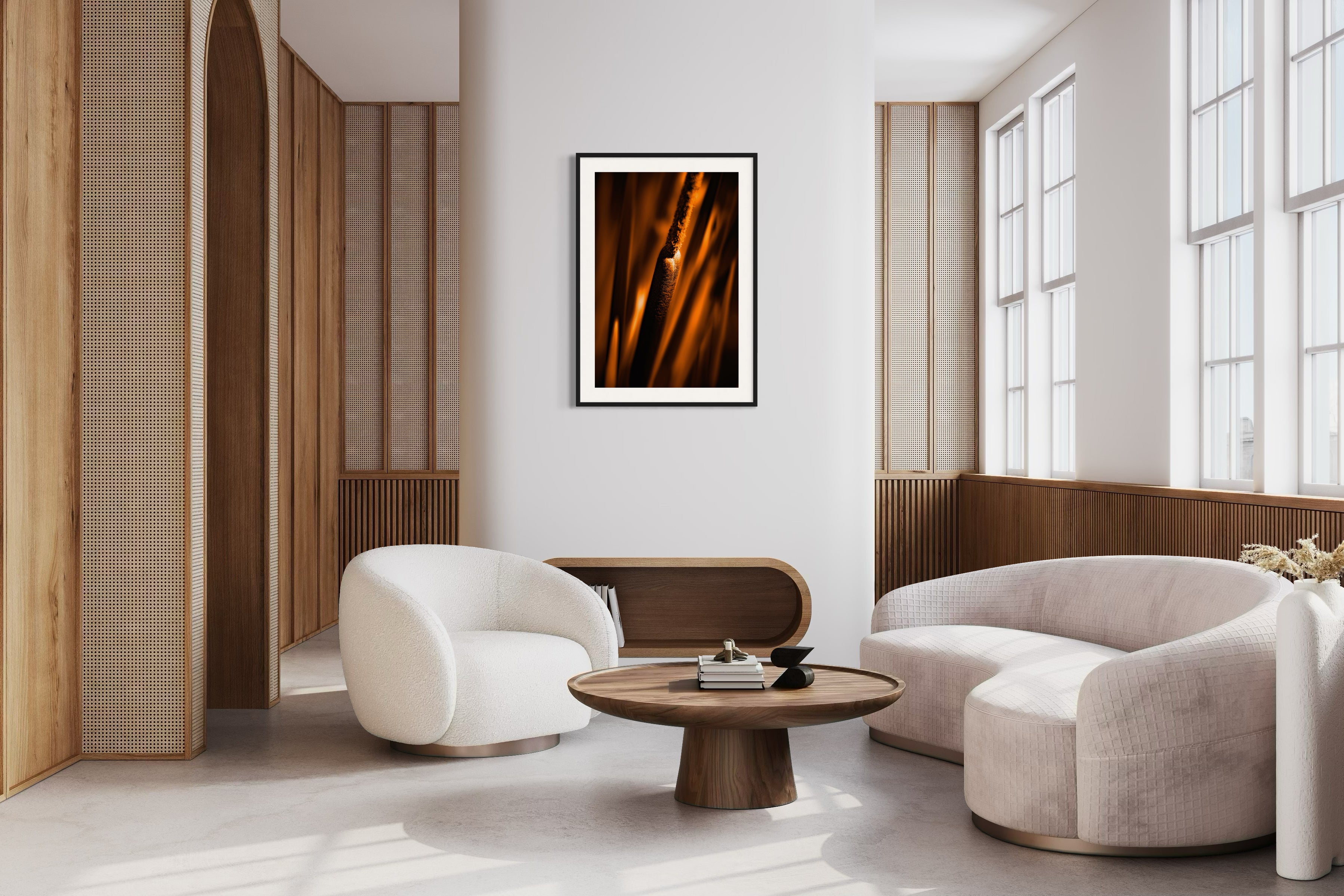reeds in gold tone with selective focus photo in black frame on tan wall in modern earthy living room with large windows