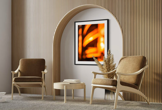 photo of abstract orange blurred lines in black frame with white matte on wall in modern earthy sitting area