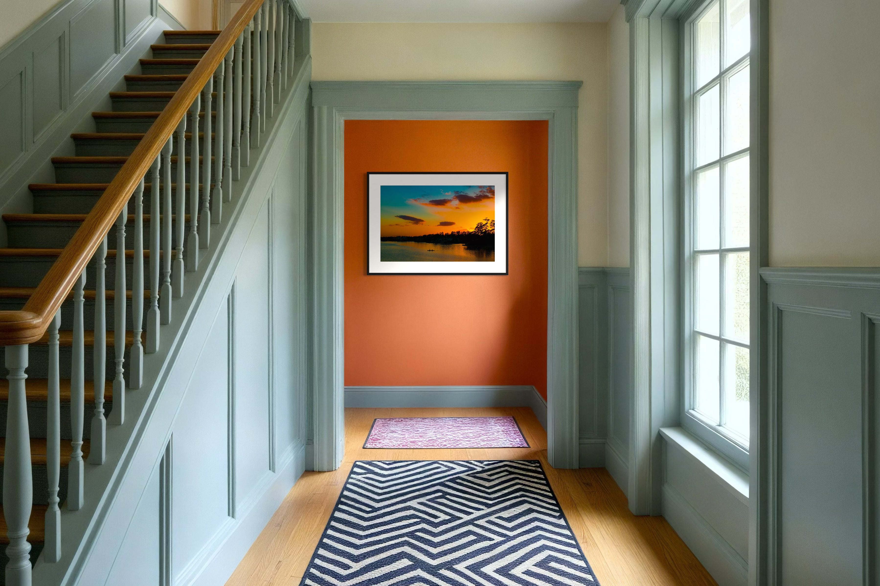 wide angle photo of kayak on lake at sunset in black frame with white matte on orange wall in country style home