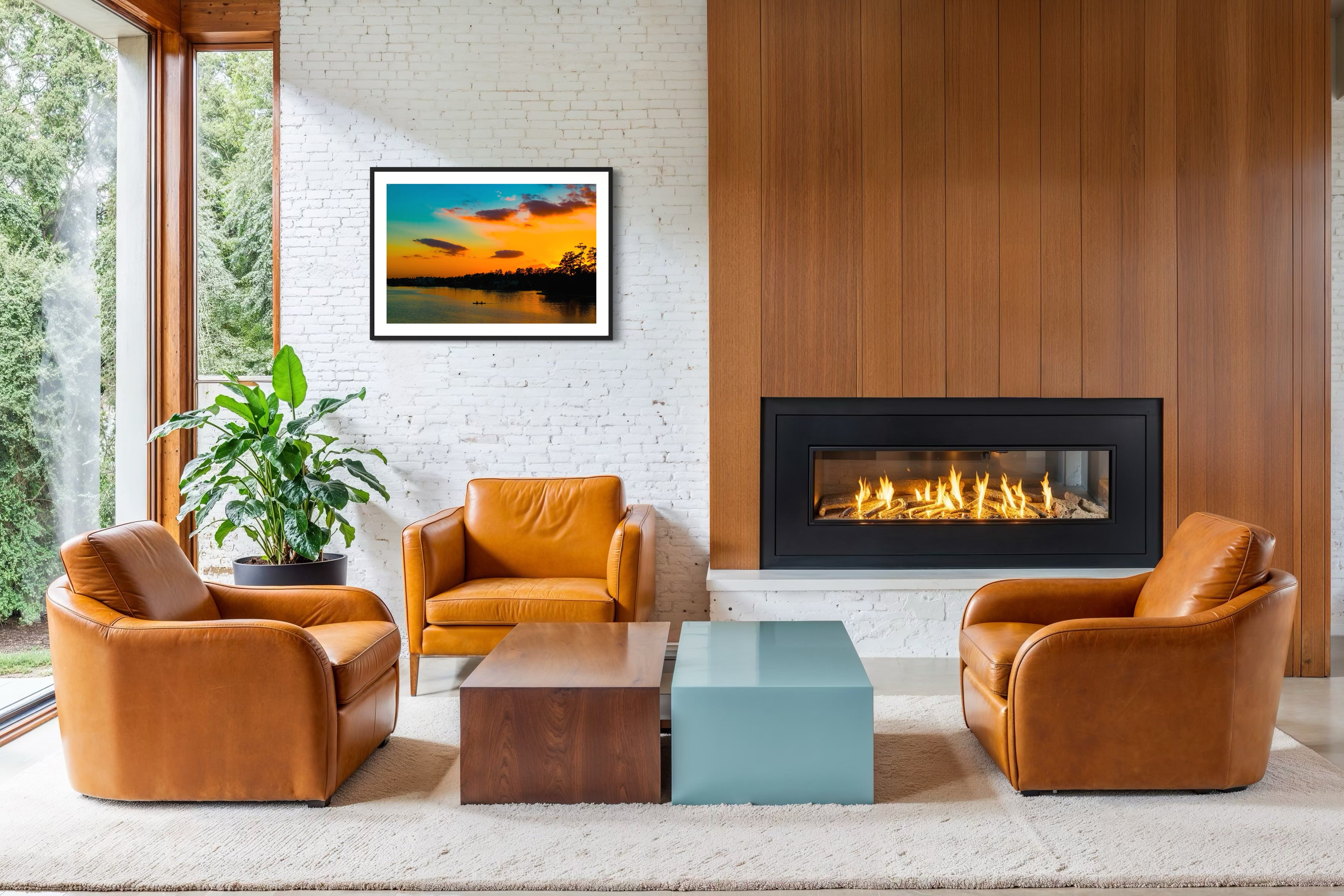 wide angle photo of kayak on lake at sunset in black frame with white matte on white brick wall in modern living room with leather chairs and concrete floors