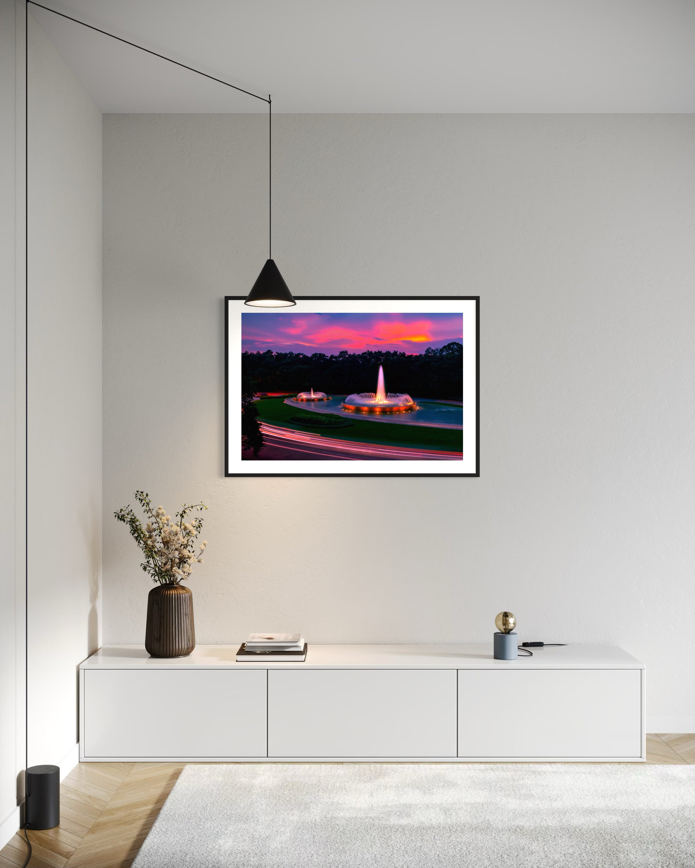 photo of Mecom Fountain in Houston shot at sunset with blurred car lights at the bottom in black frame with white matte on off white wall in modern home office with mostly white or light gray tones and light hardwood floors