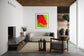 photo of blurry red leaf on blurred bright green background in black frame with white matte on white wall in industrial and modern living room