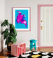bright pop art photo of pink lily on blue background in pink frame on wall in funky colorful room