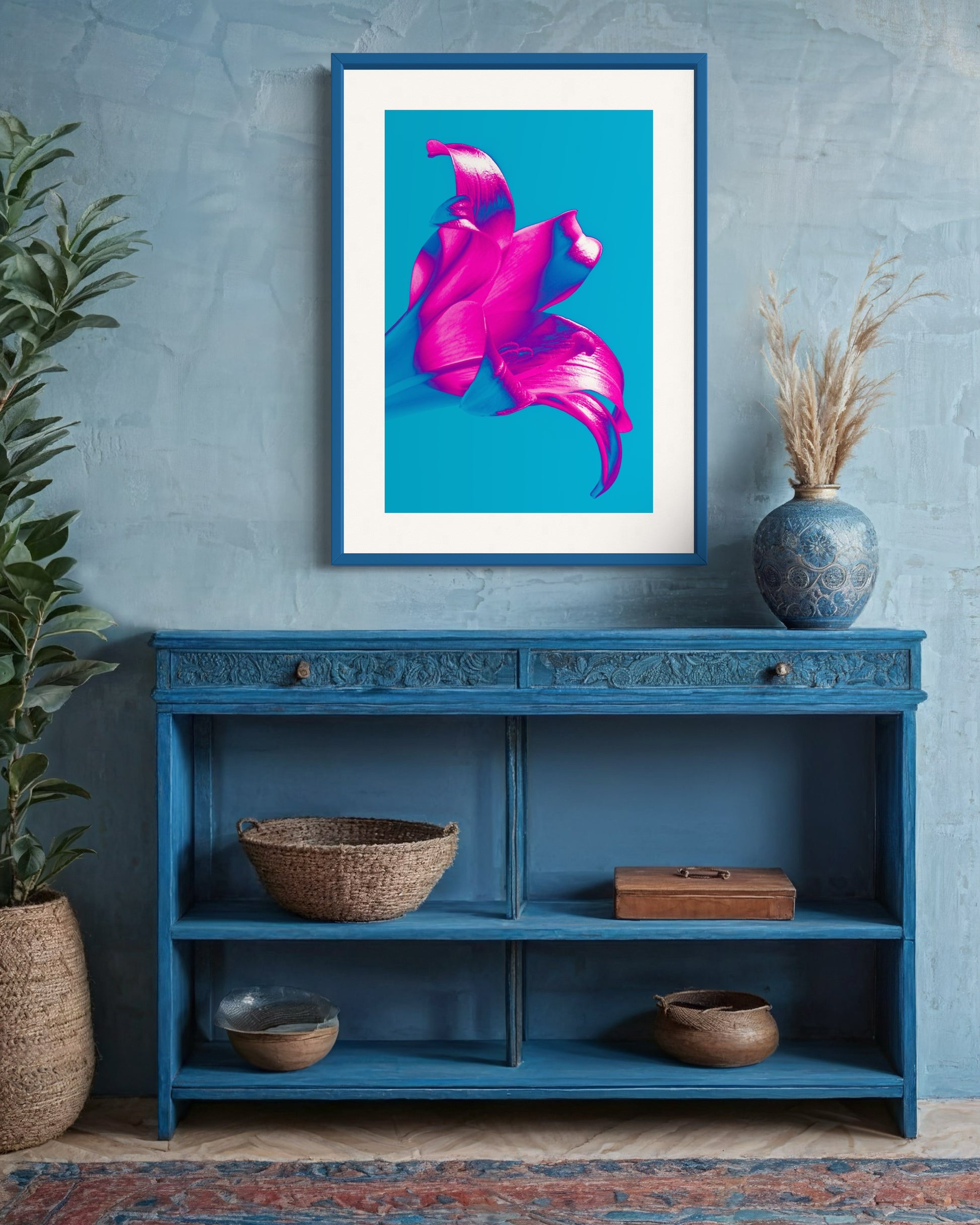 bright pop art photo of pink lily on blue background in blue frame above small blue table in rustic room with blue walls