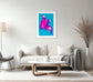 bright pop art photo of pink lily on blue background in gray frame with light gray matte above white couch in modern living room with white and light gray tones