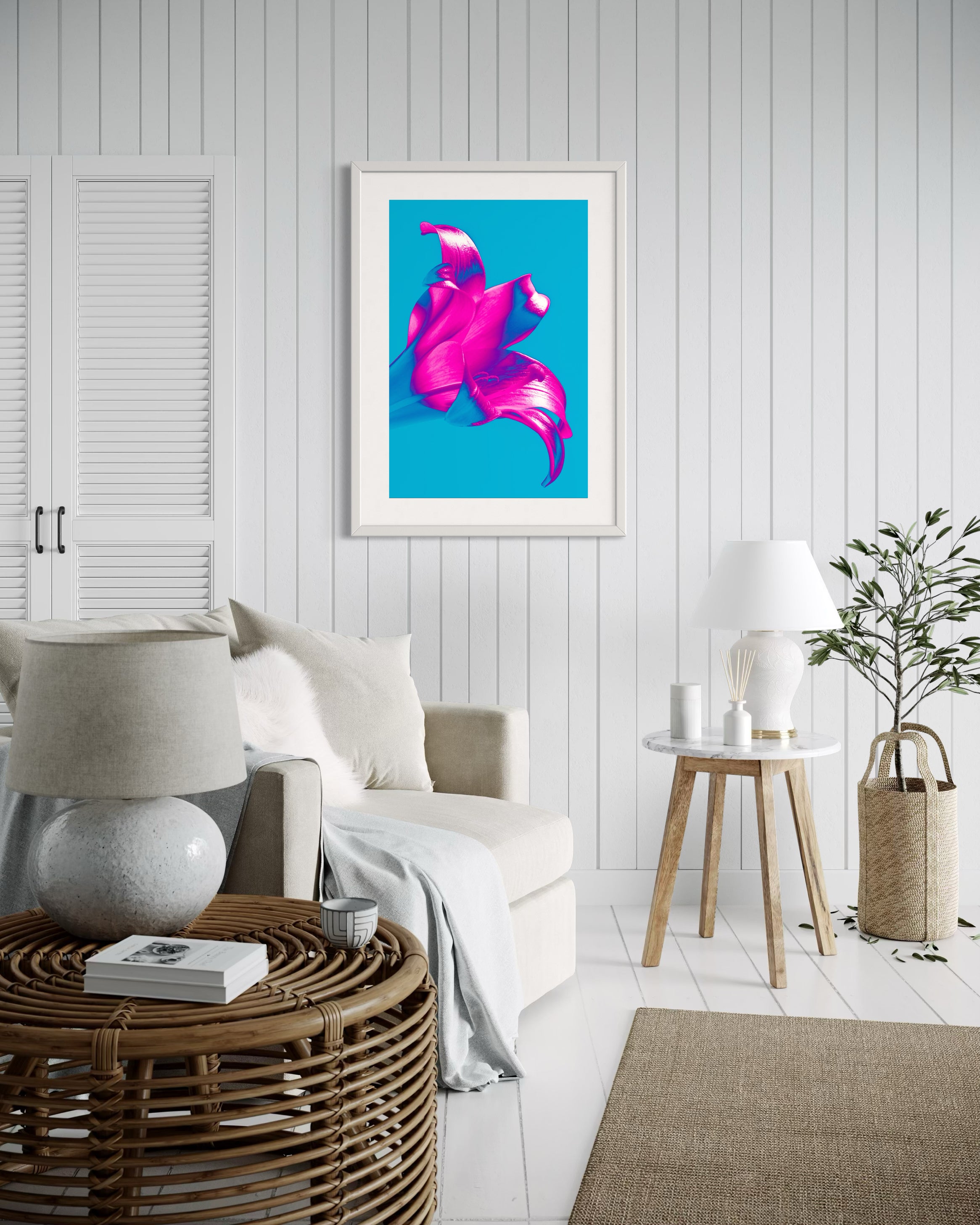 bright pop art photo of pink lily on blue background in gray frame with light gray matte in coastal style sitting room with white and tones