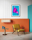 bright pop art photo of pink lily on blue background in black frame with white matte on wall in colorful sitting room with yellow chair room