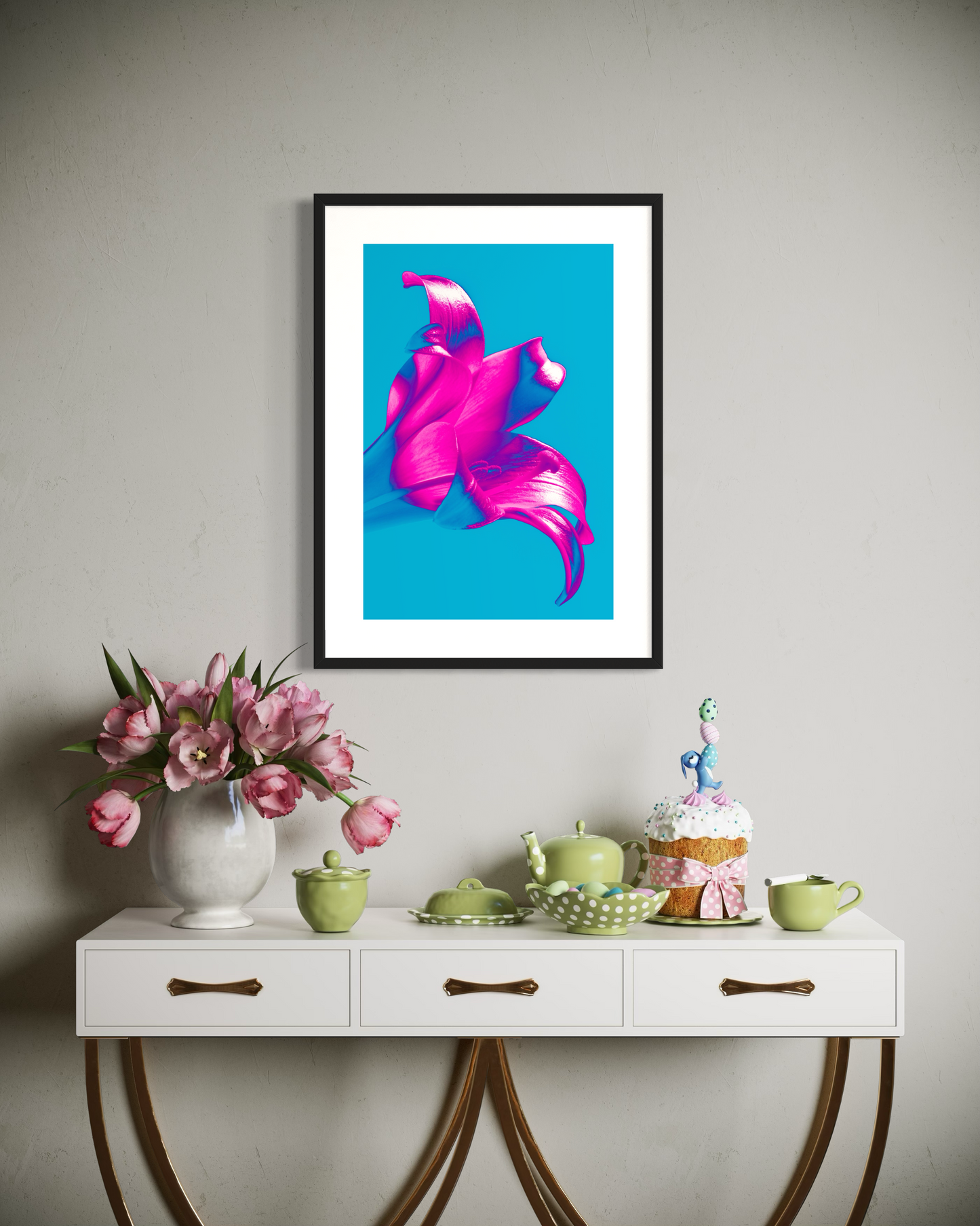 bright pop art photo of pink lily on blue background in black frame above small blue table with flowers, tea set and small, tall cake