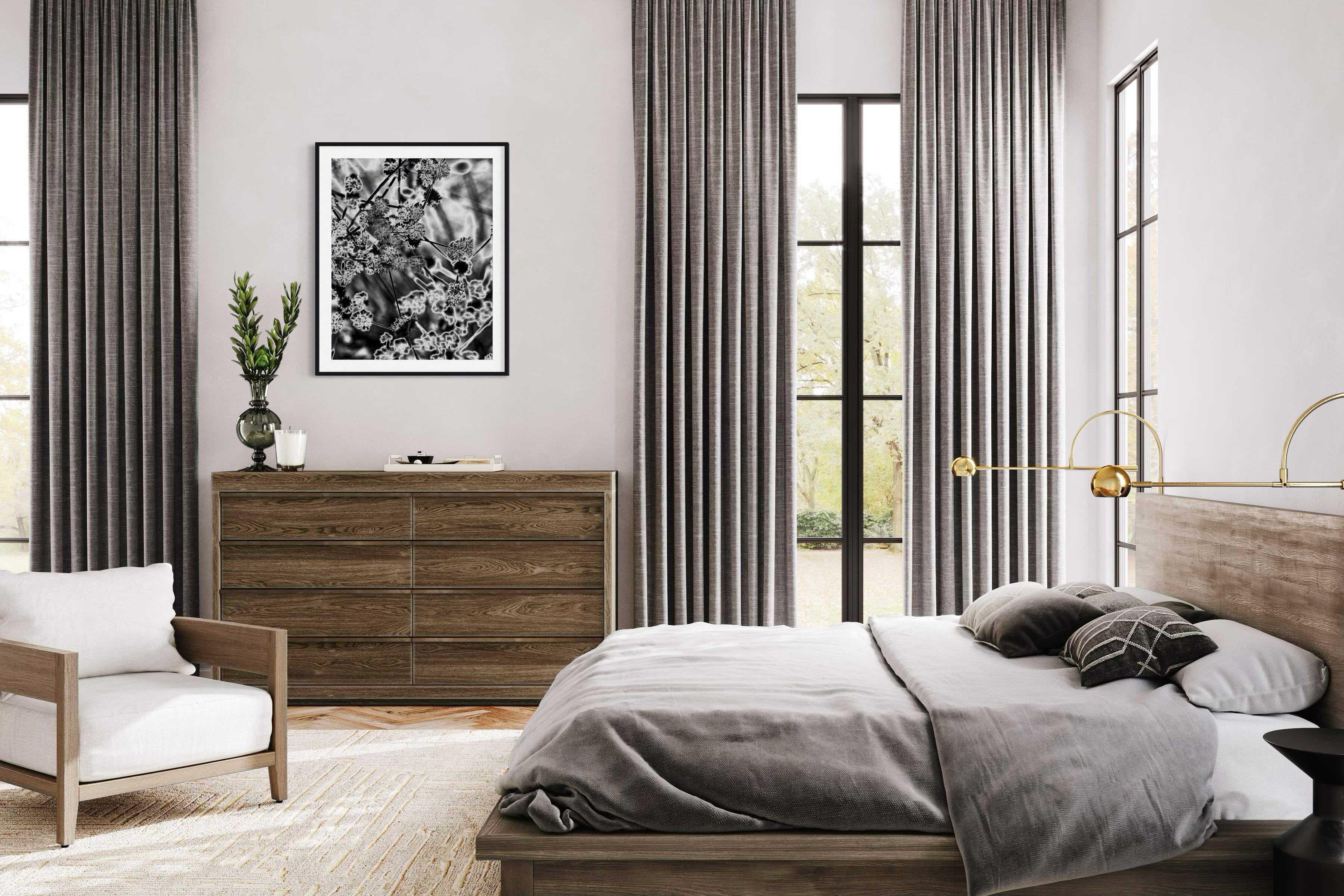 black and white close up of plant with solarized effect in black frame with white matte above small wide wooden piece of furniture with drawers in rustic bedroom