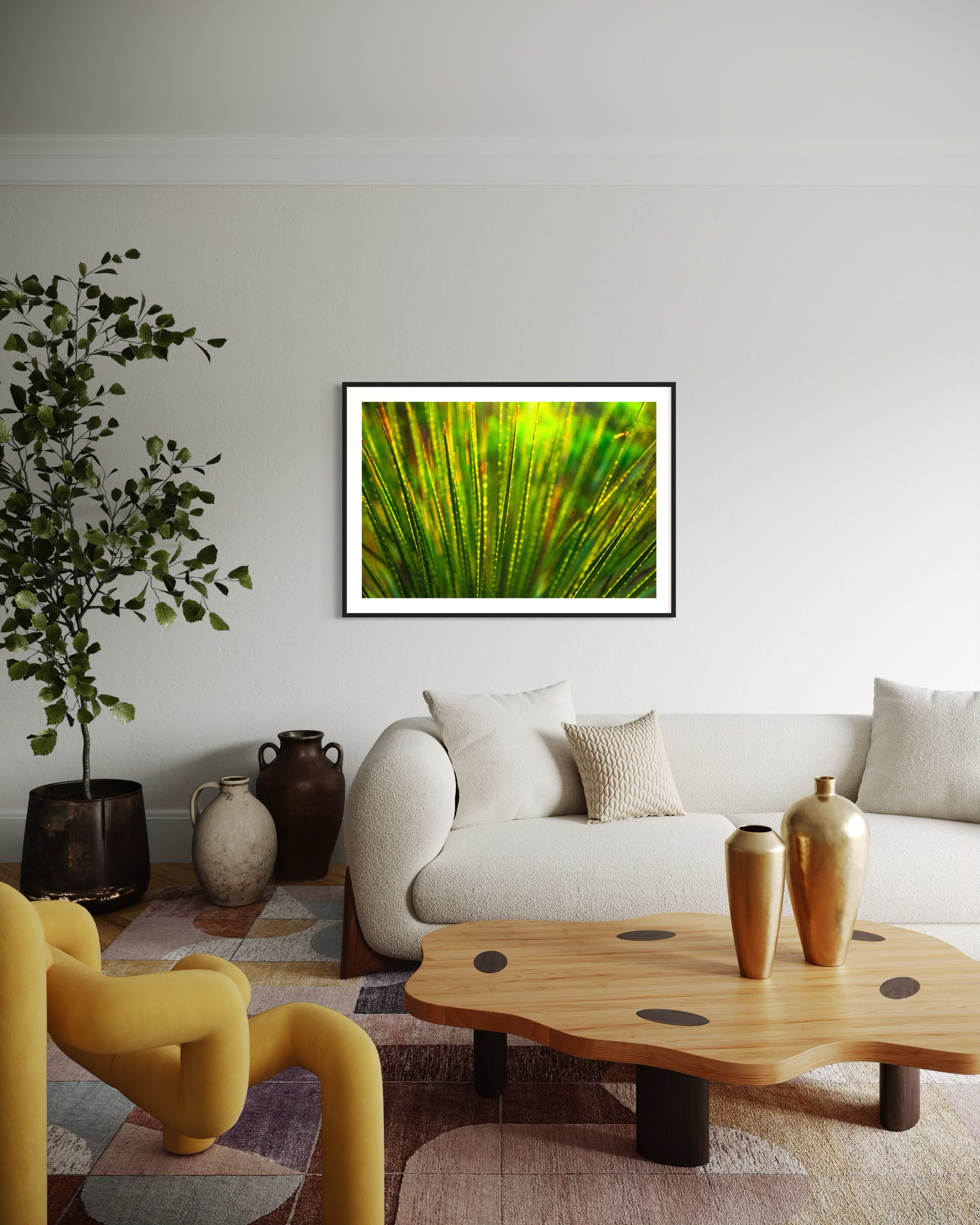photo close up of Sotol plant backlit at dusk in black frame with white matte on white wall in eclectic living room with white couch, random shaped wooden coffee table and funky yellow chair 