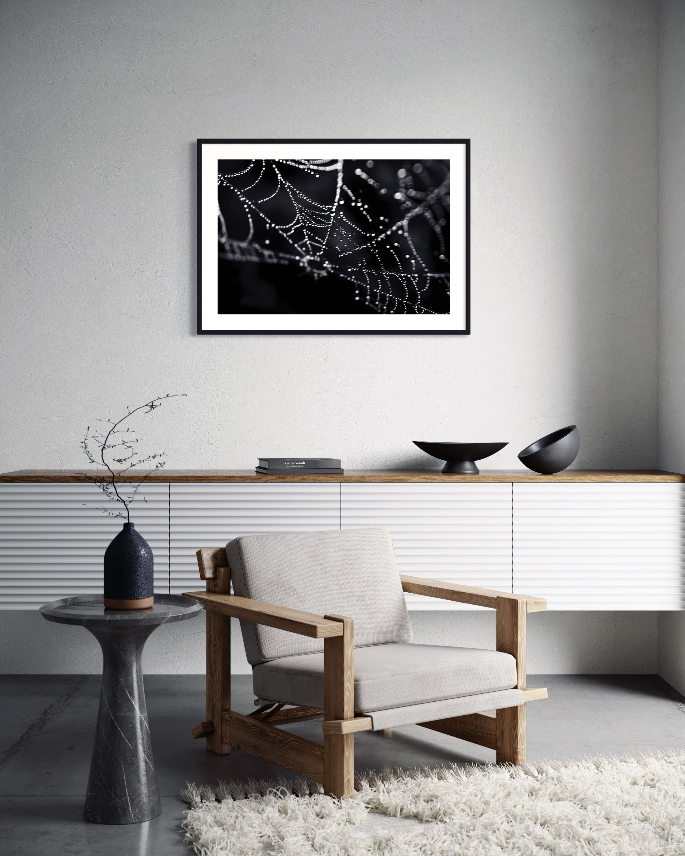 close up photo of rain drops on spider web in black and white in black frame on white wall in modern minimalist sitting area