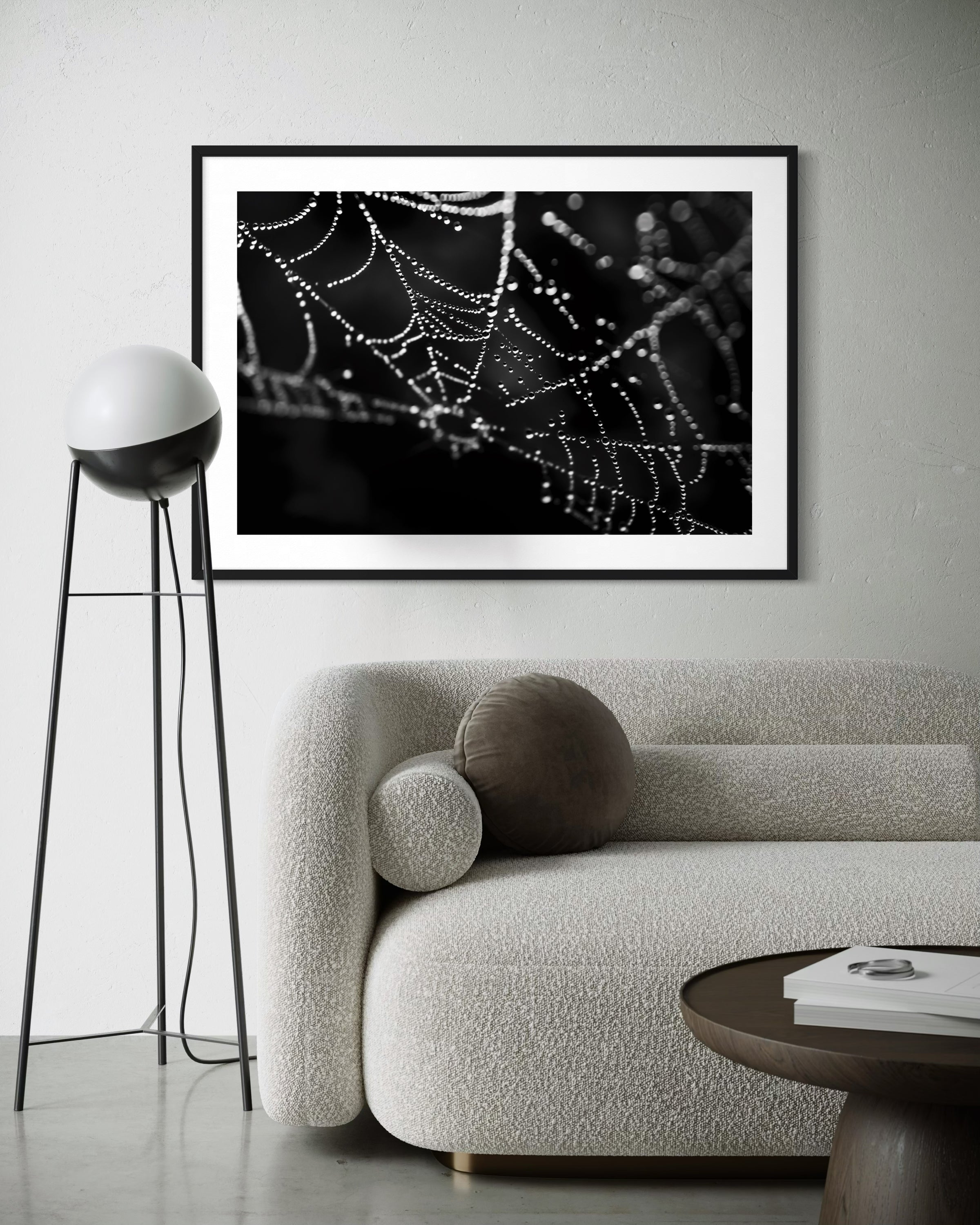 close up photo of rain drops on spider web in black and white in black frame with white matte on white wall in modern minimalist living room