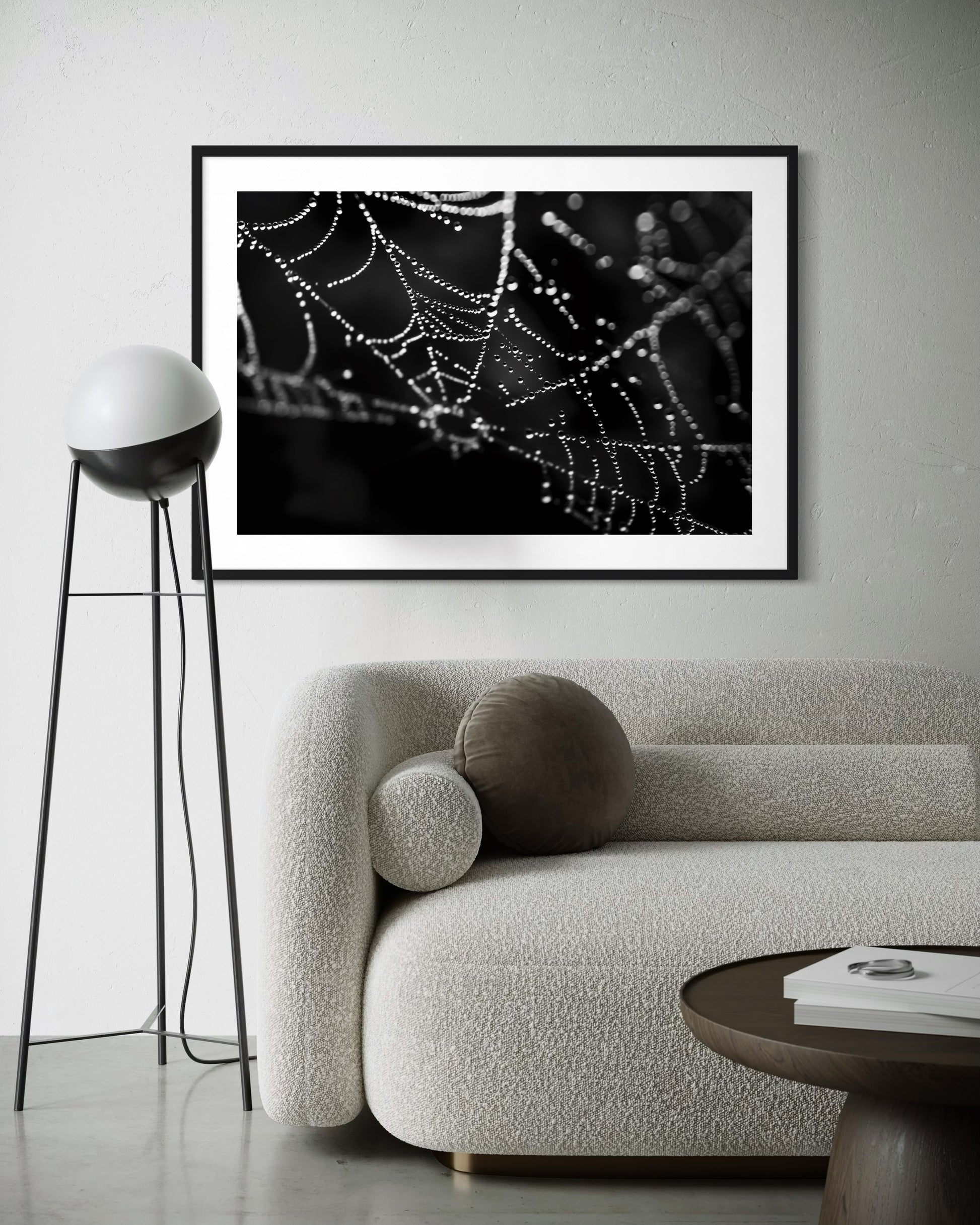 close up photo of rain drops on spider web in black and white in black frame with white matte on white wall in modern minimalist living room