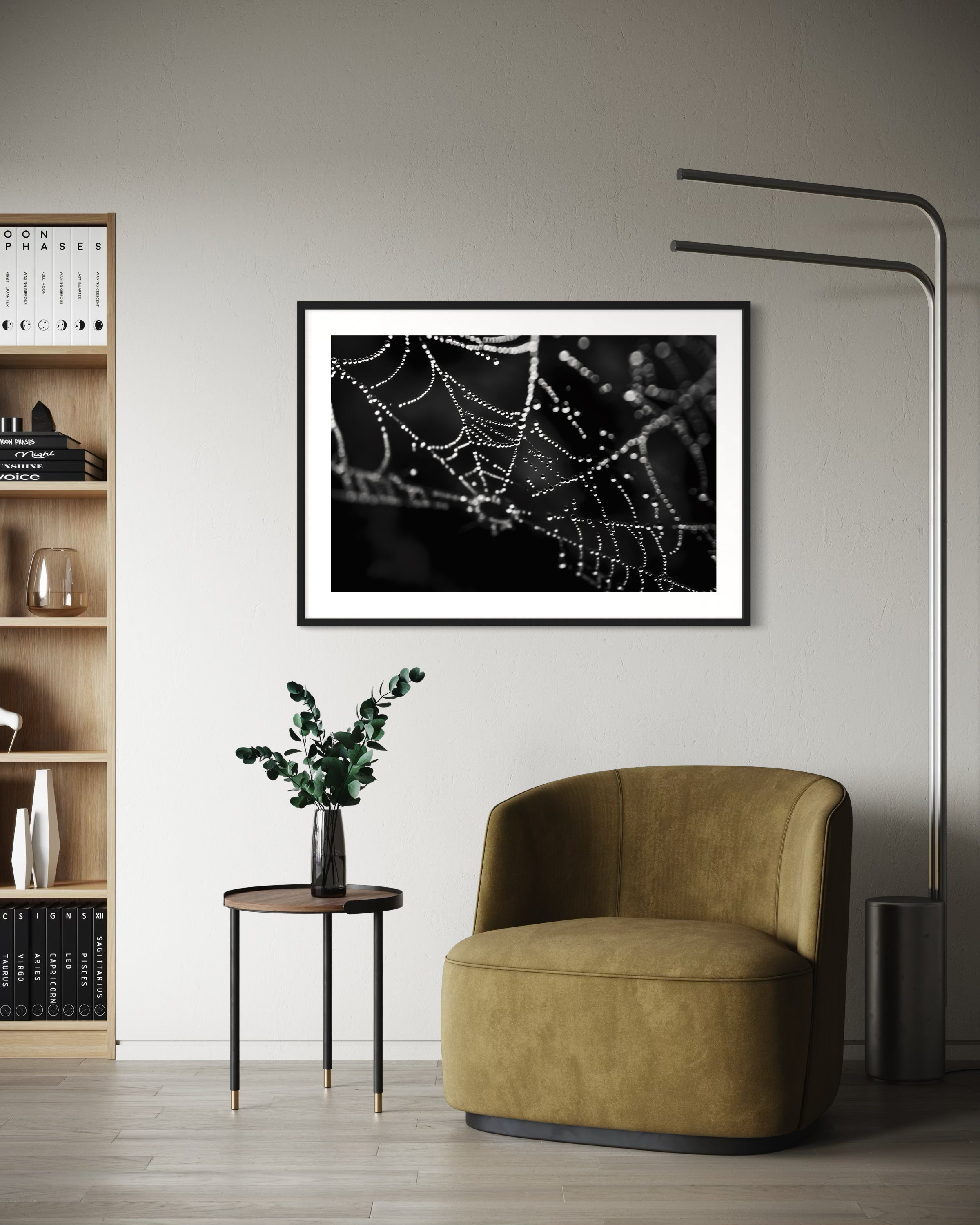 close up photo of rain drops on spider web in black and white in black frame with white matte on off white wall in modern minimalist sitting area