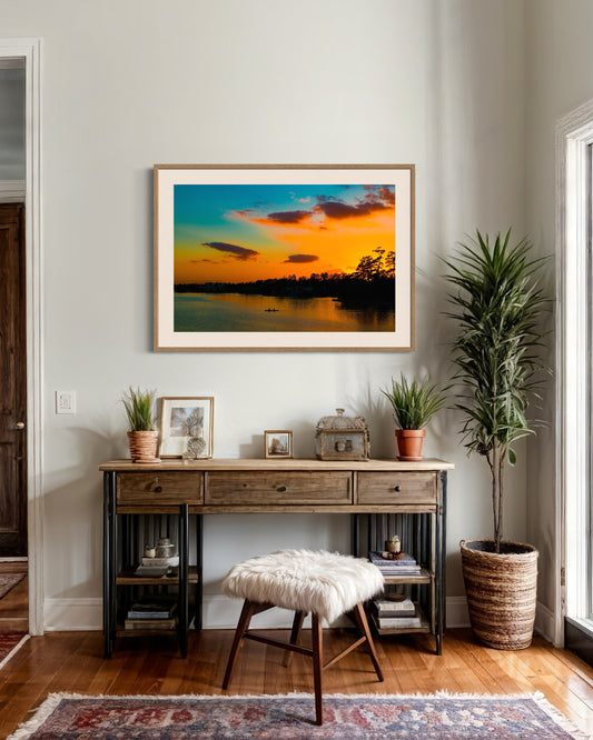 wide angle photo of kayak on lake at sunset in natural wood frame with off white matte on white wall in rustic sitting area
