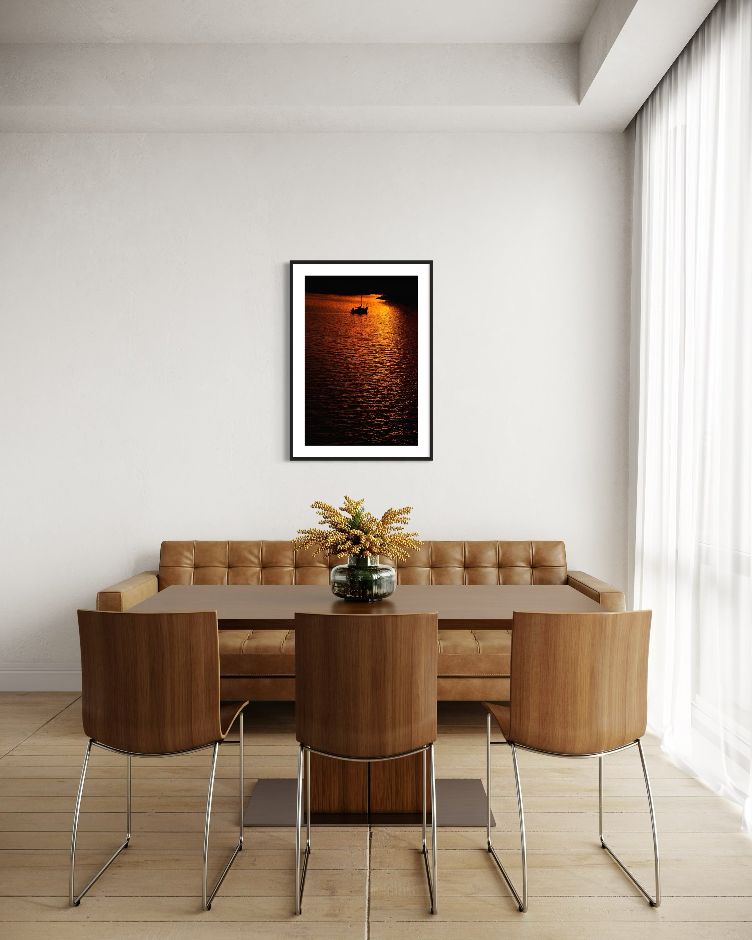 photo of sailboat sailing at sunset, in a very warm tone in black frame with white matte on white wall above couch in modern home  dining area 