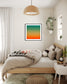 photo, gradient top to bottom teal blue, pale yellow and then orange in black frame with off white matte on white wall in Scandinavian style bedroom 