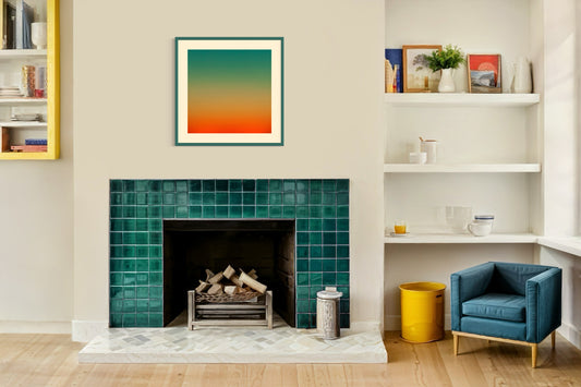 photo, gradient top to bottom teal blue, pale yellow and then orange in teal frame with off white matte on off white wall above fireplace in room with bright, colorful accents