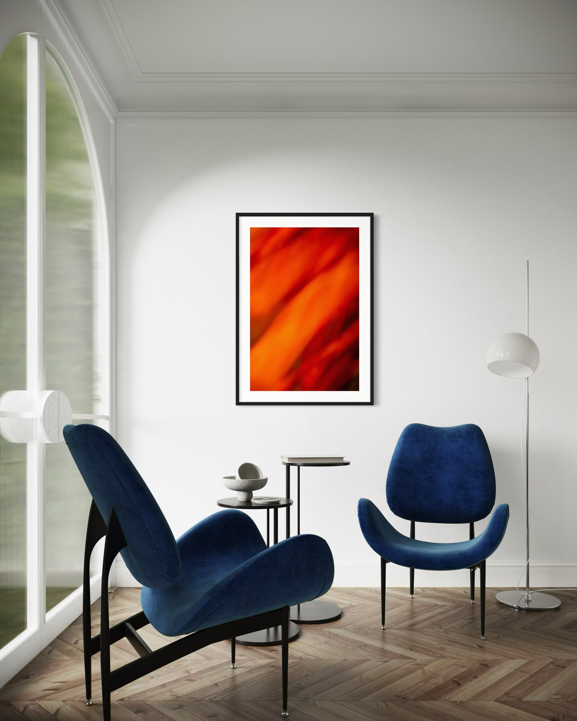 orange abstract with upward motion in black frame with white matte on white wall in modern sitting area with two blue chairs