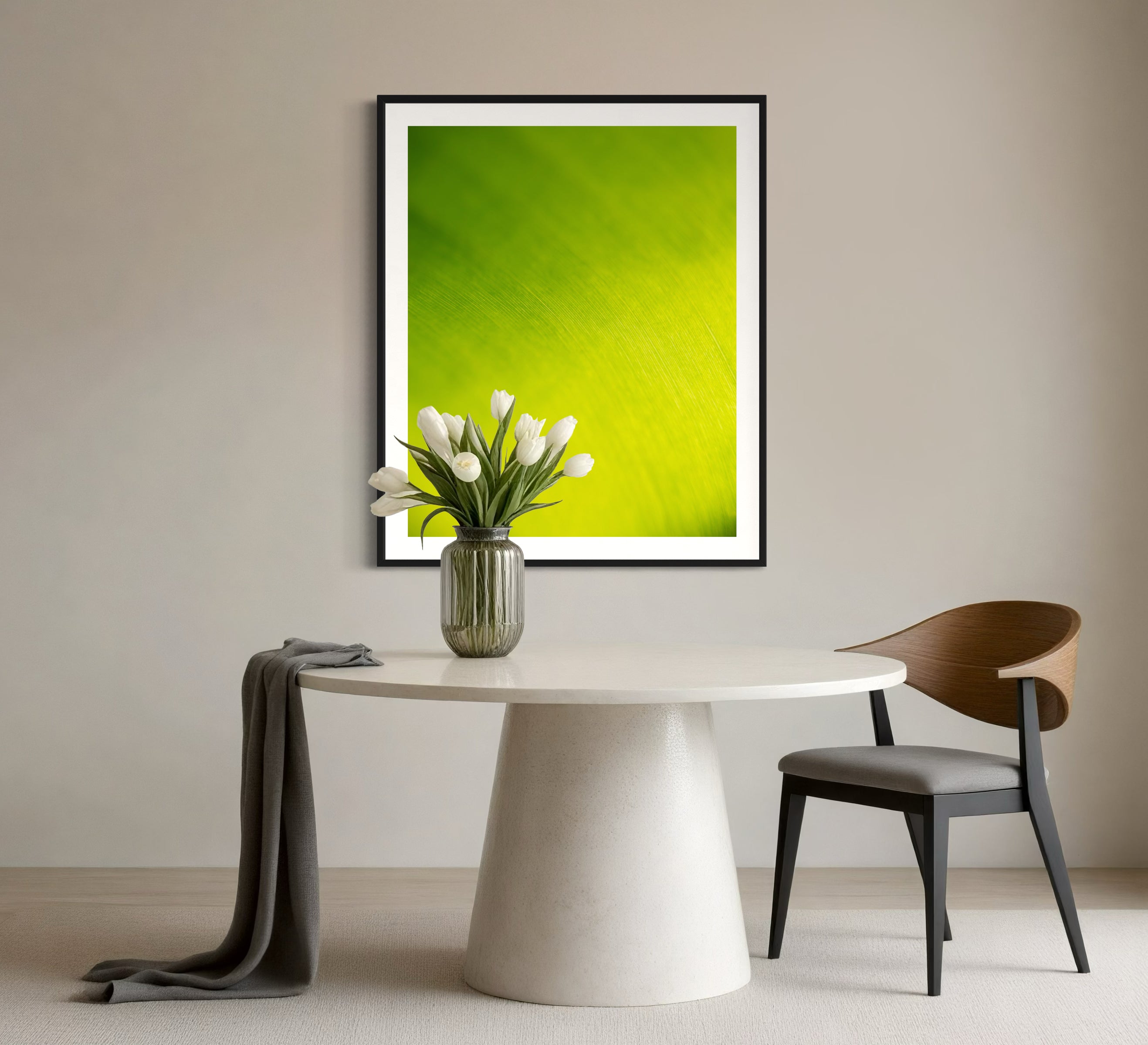close up of large tropical leaf with the lines flowing like a waterfall in black frame with off white matte on white wall wall in minimalist breakfast area 