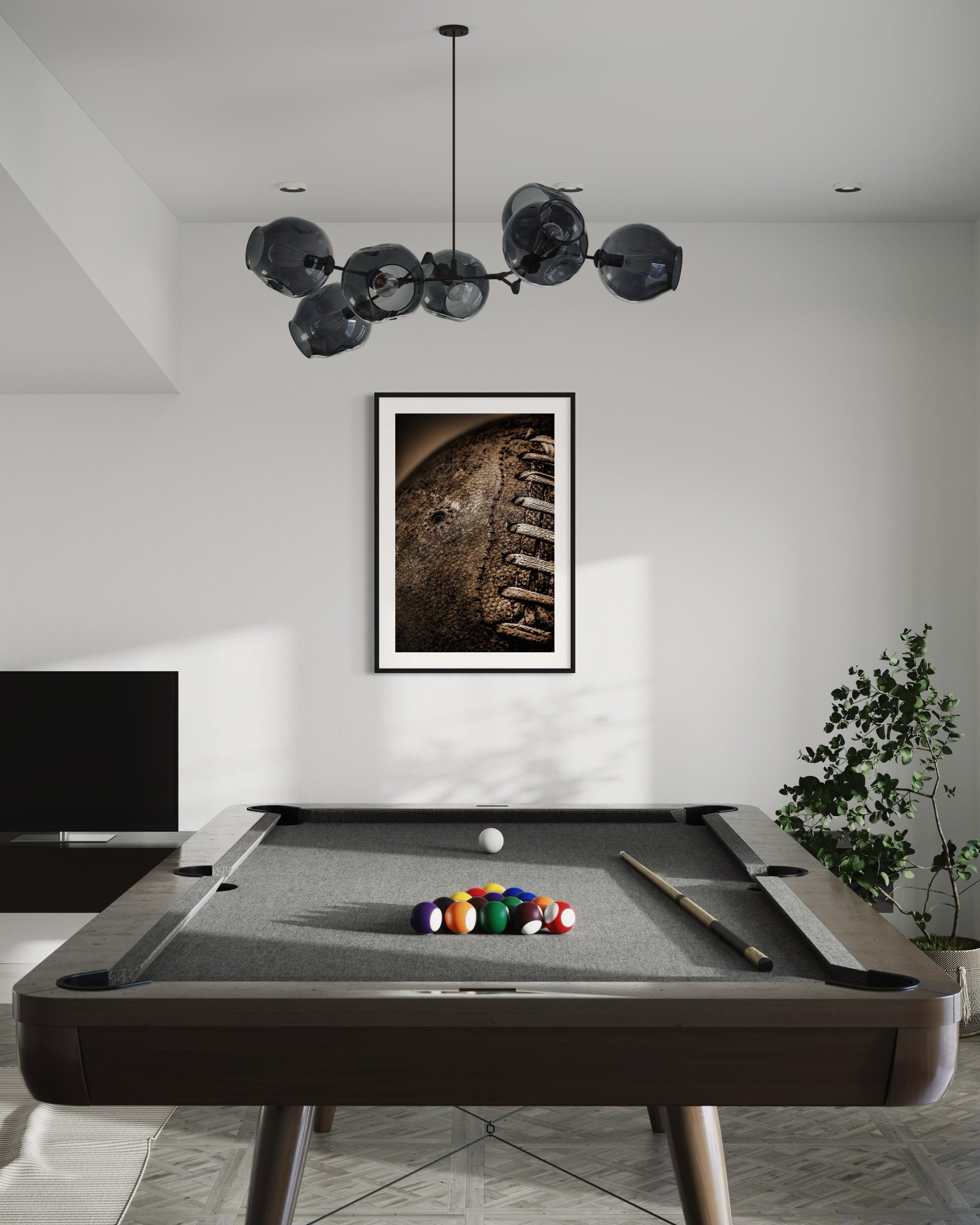 Sepia tone old football close up in a grungy look shot in studio in black frame with white matte on white wall in game room with pool table and television