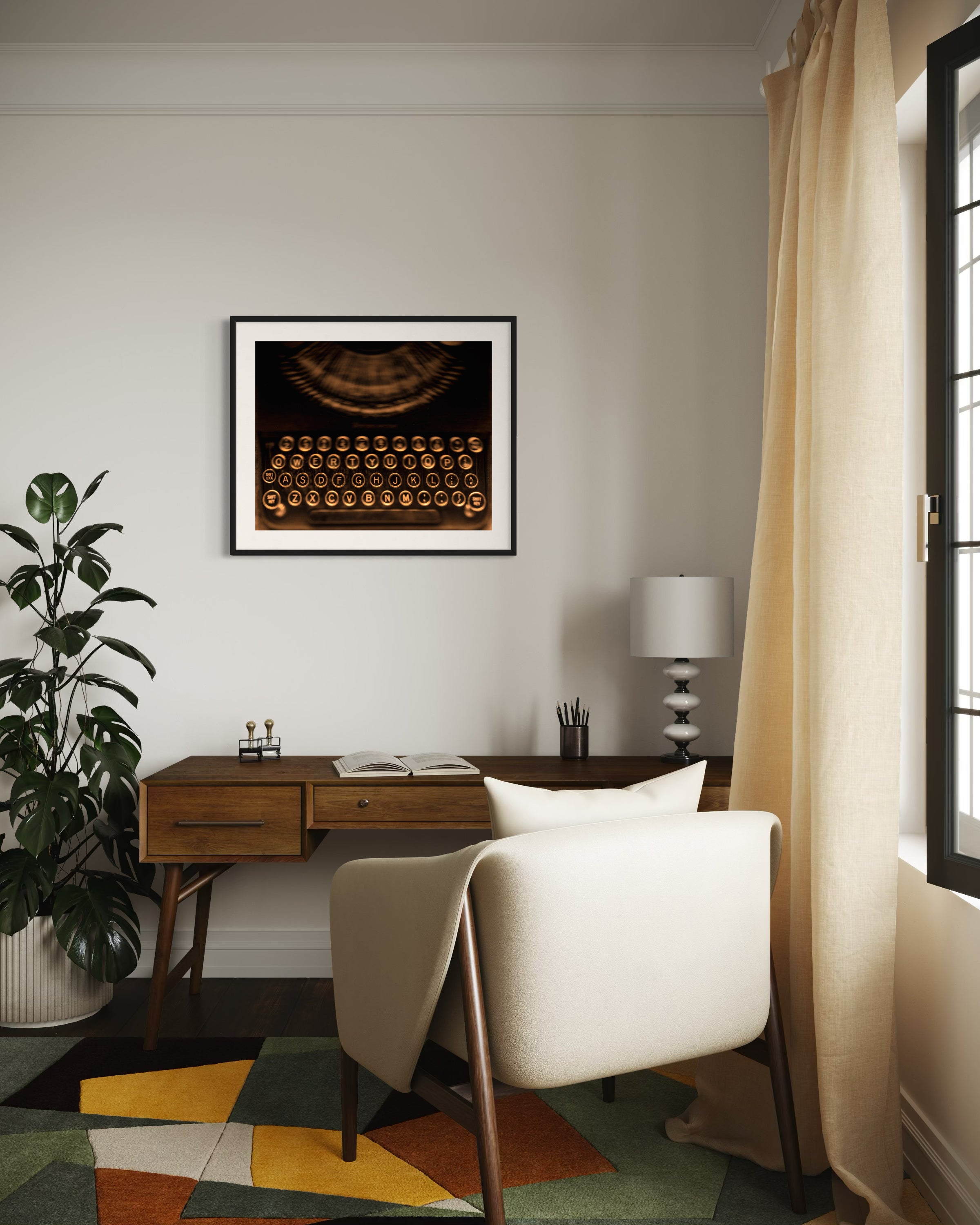 close up of old typewriter from above, horizontal black and white photo in black frame with white matte on wall above wooden desk in home office