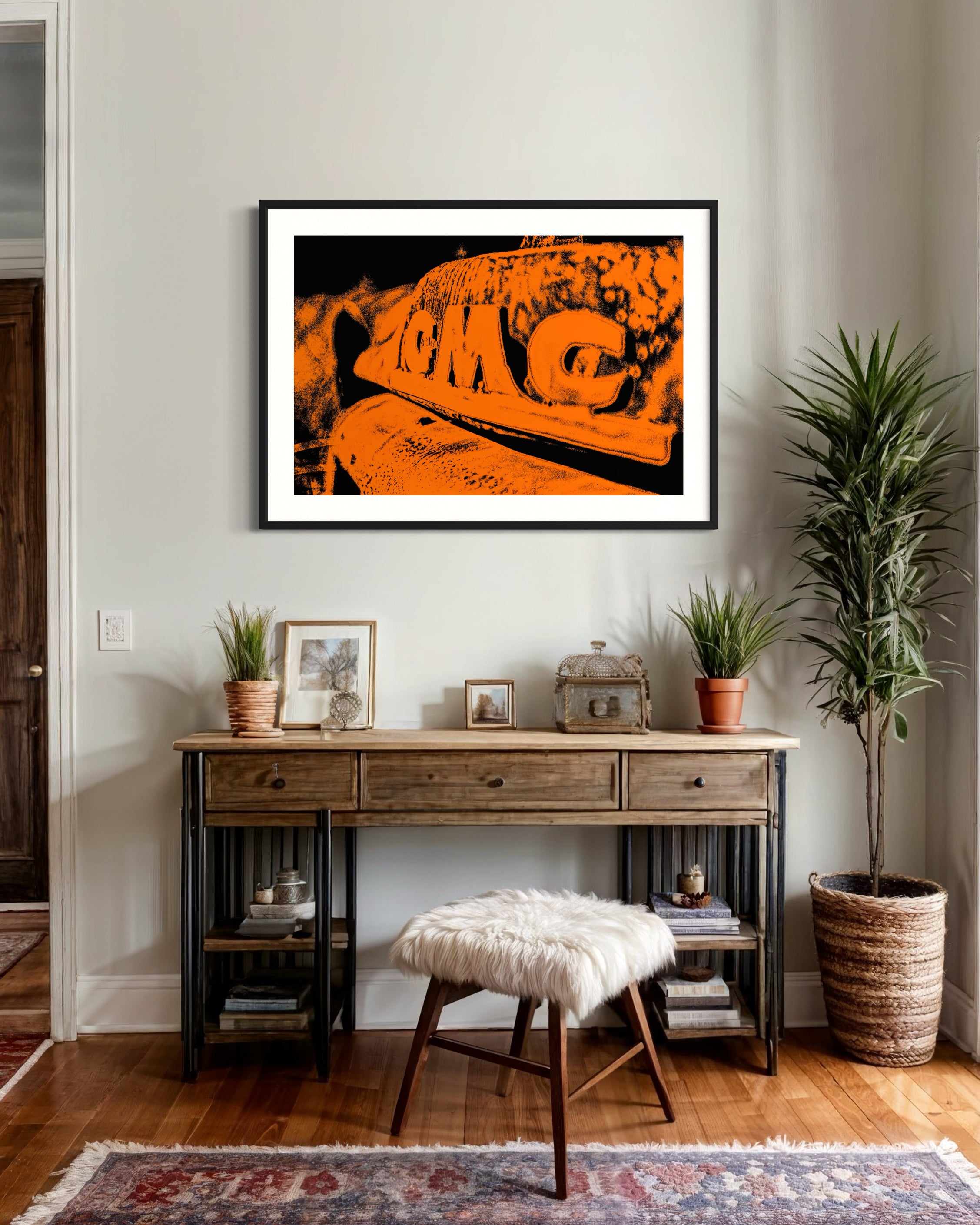 orange tone photo of front of old truck in black frame with white matte on white wall in rustic residential sitting area