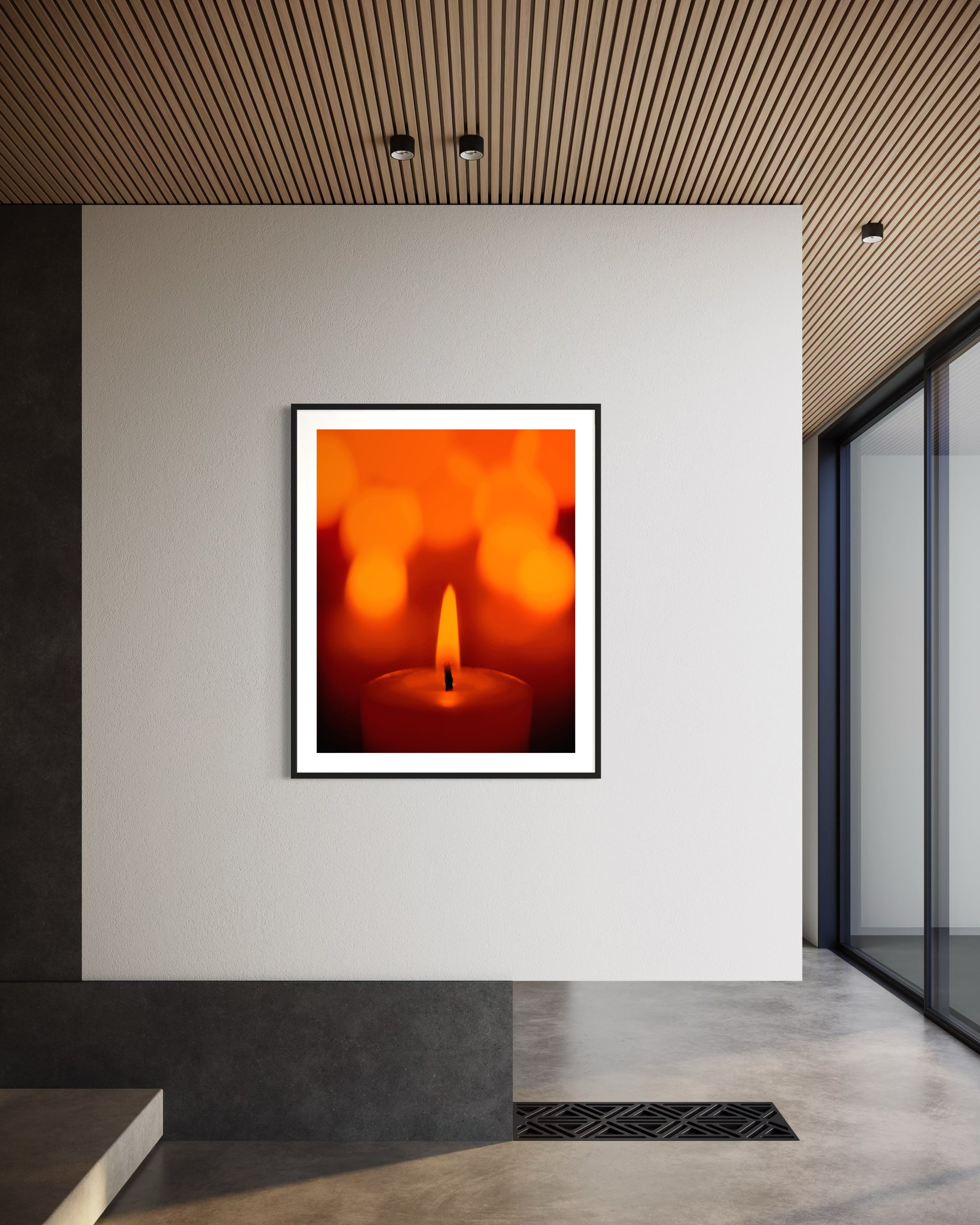 close up photo of single candle with other candles out of focus in the background in black frame with white matte on white wall in modern minimalist home 