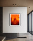 close up photo of single candle with other candles out of focus in the background in black frame with white matte on white wall in modern minimalist home 