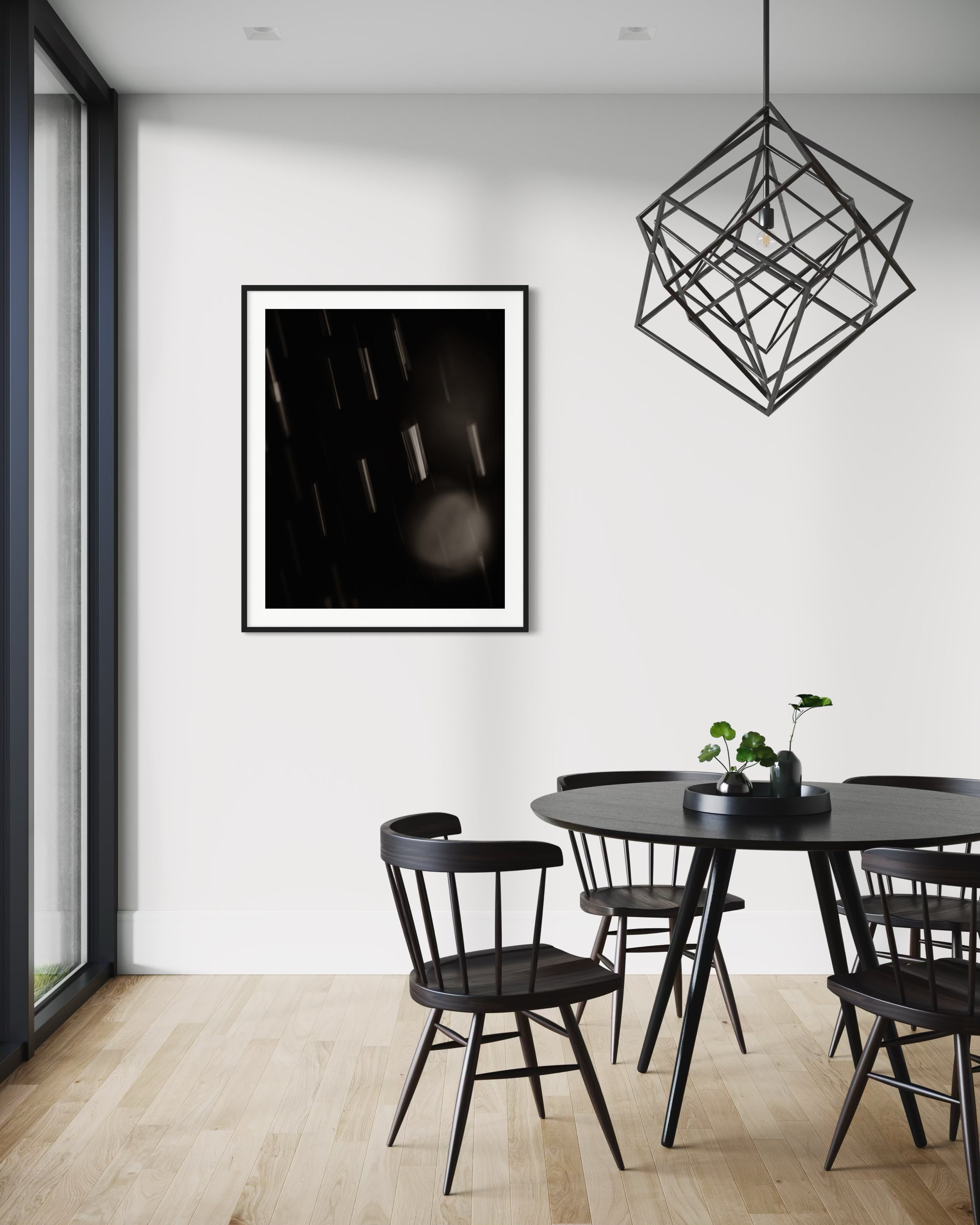 close up warm toned photo of streaks of rain in black frame with white matte on white wall in modern casual dining area with black table and chairs