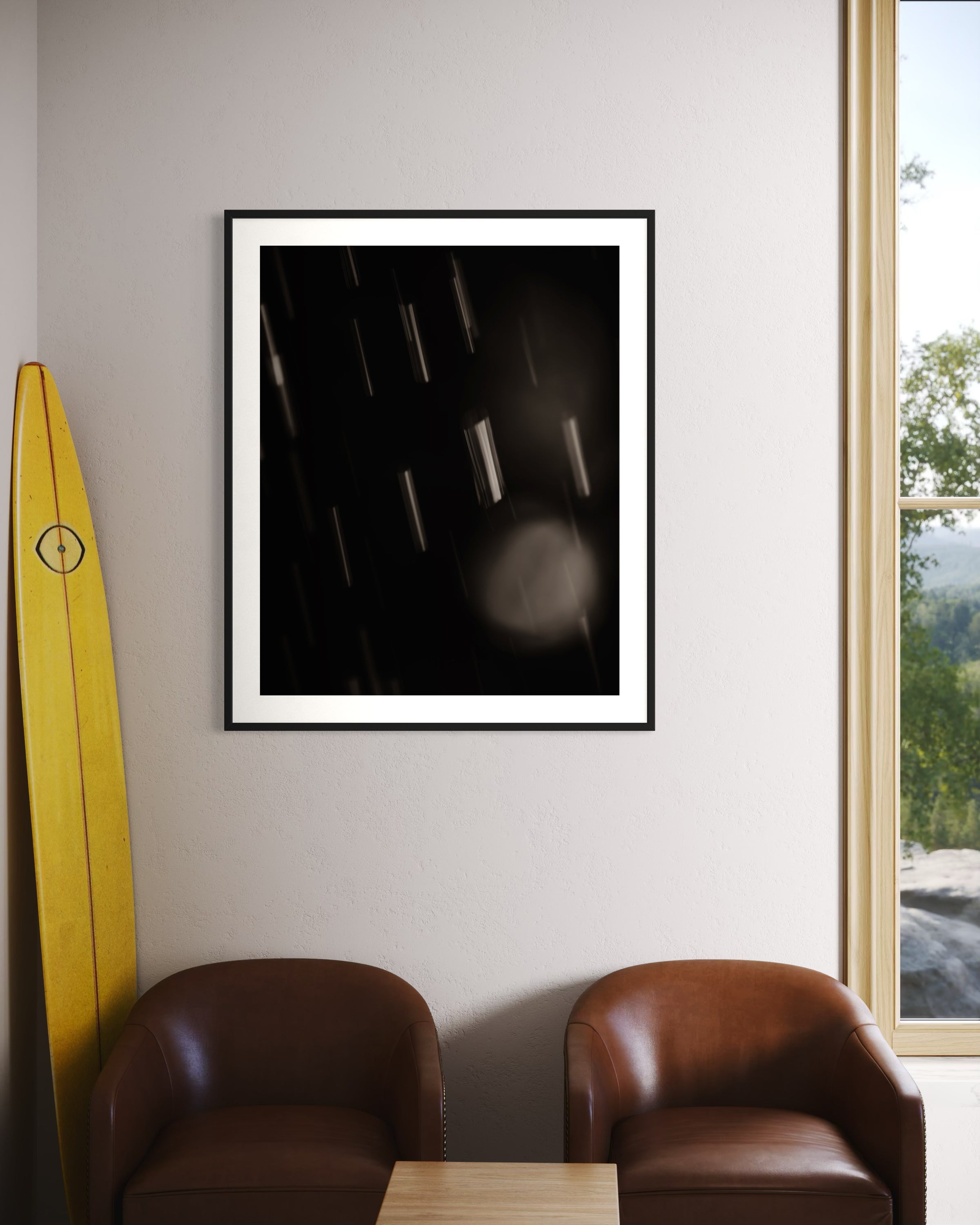 close up warm toned photo of streaks of rain in black frame on off white wall above two leather chairs in corner of home