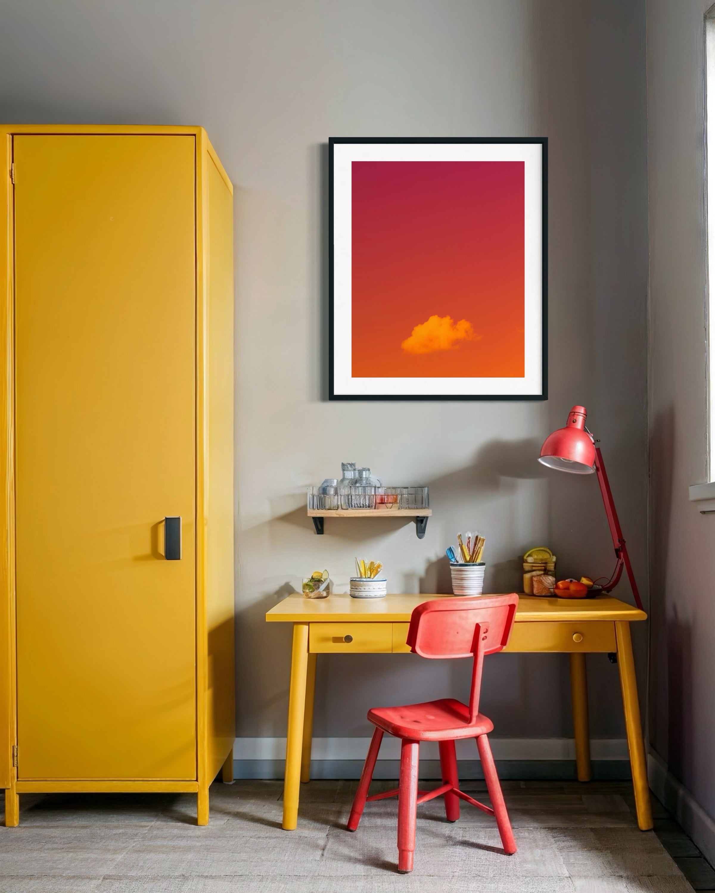 Yellow cabinet, red chair, and desk with a colorful abstract painting on a gray wall.