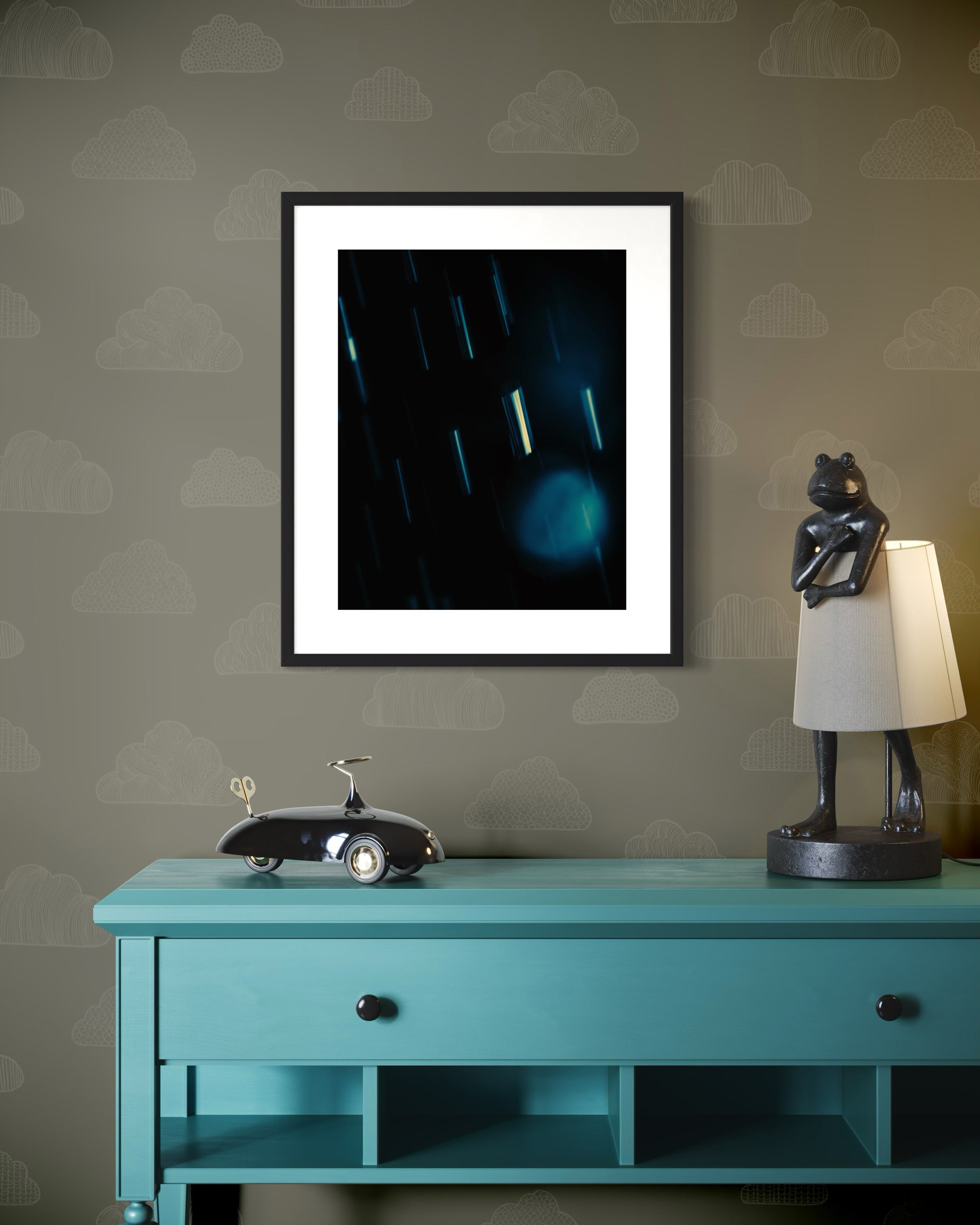 Framed artwork on a wall above a turquoise console table with decorative items.