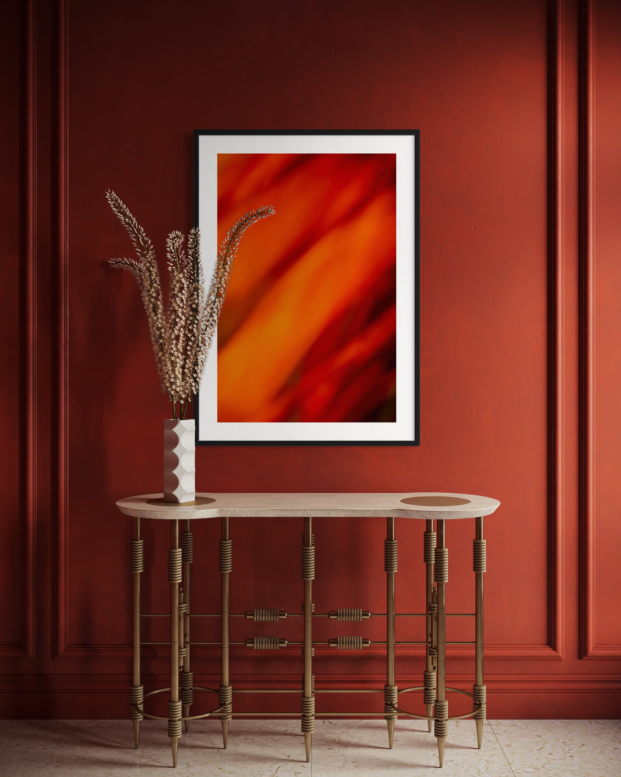 Abstract art on a red wall with a wooden side table and decorative elements.