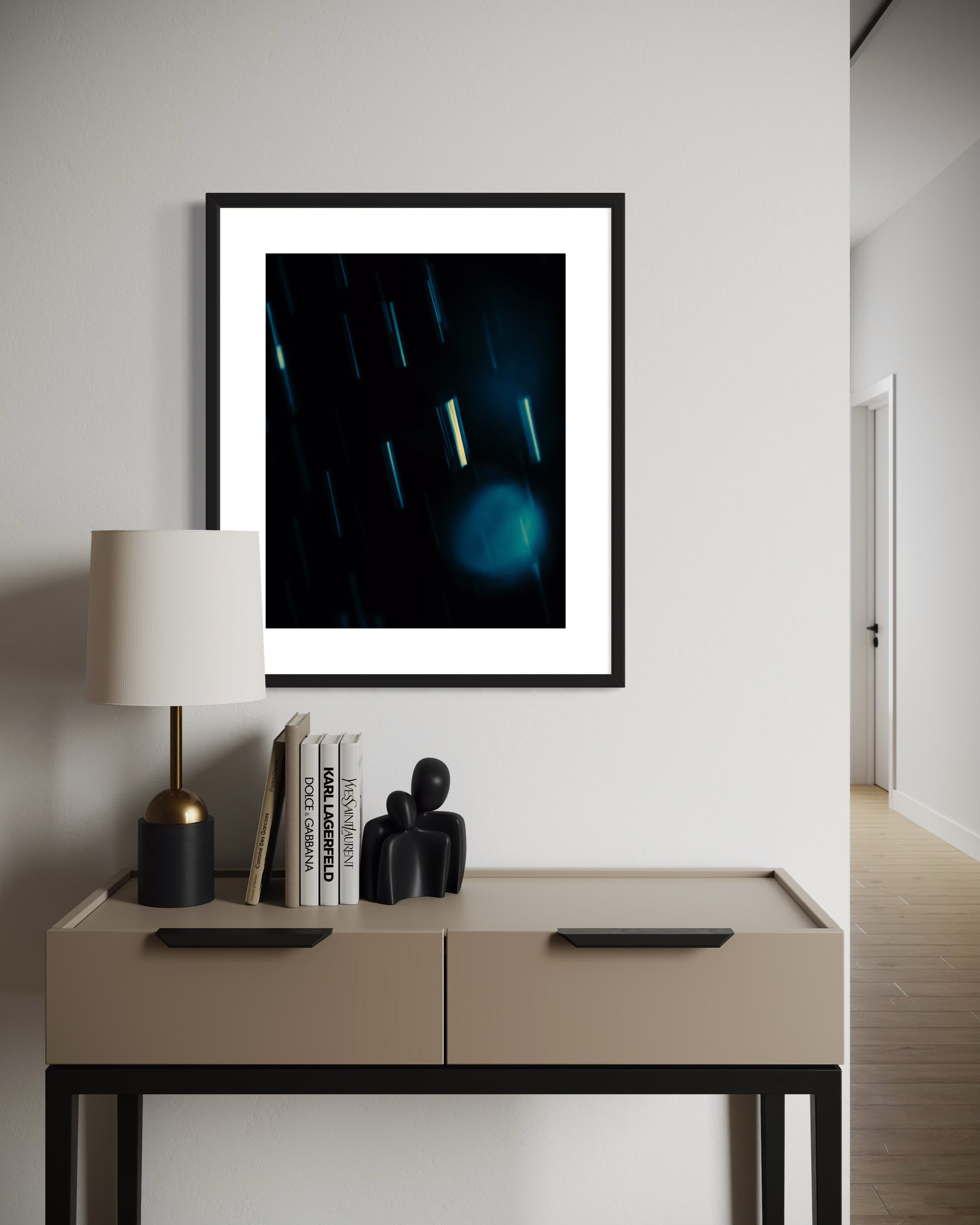 Framed artwork on a wall above a table with decor items