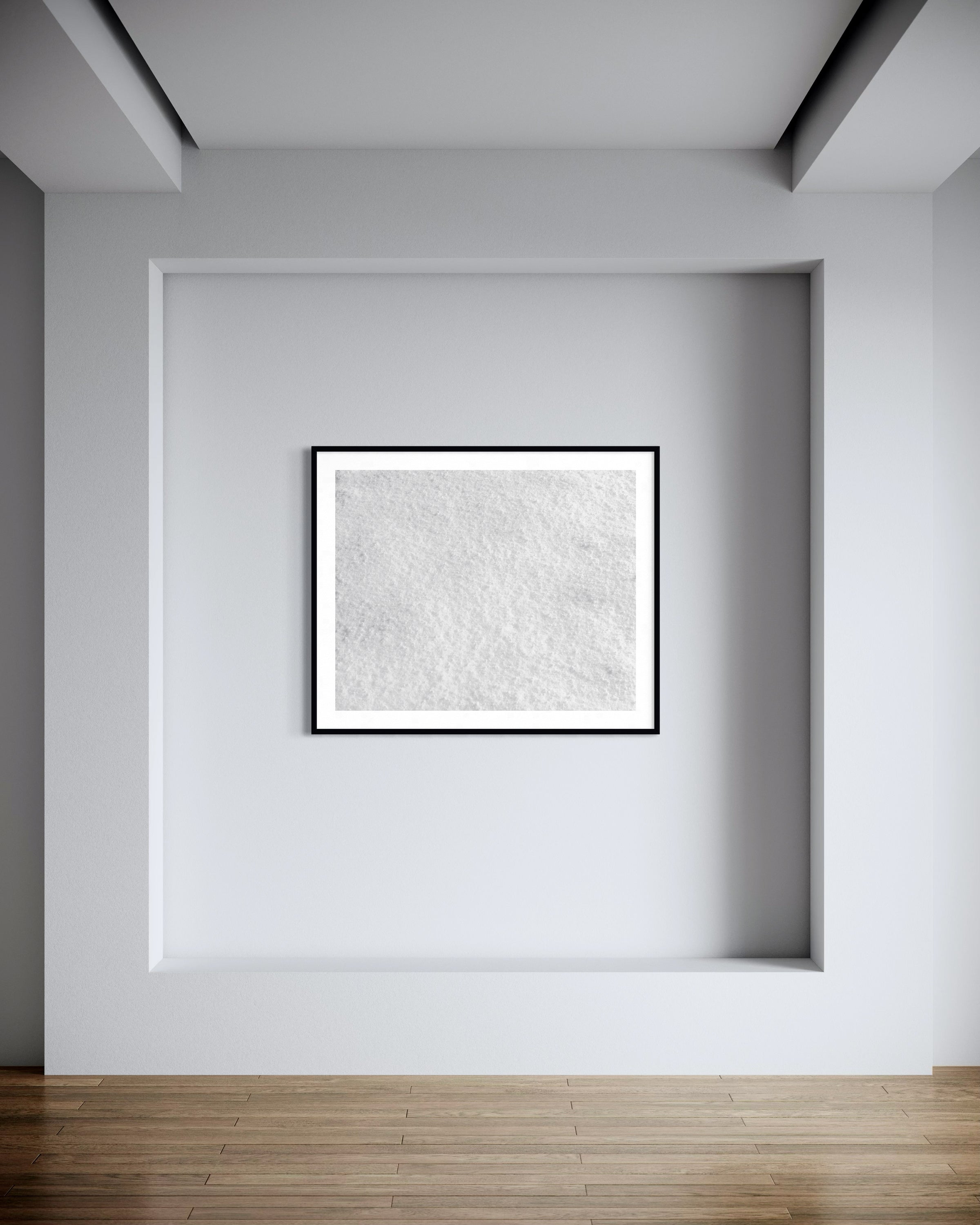 Abstract art piece in a black frame on a white wall