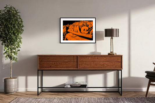 orange tone photo of front of old truck on off white wall above modern wooden table